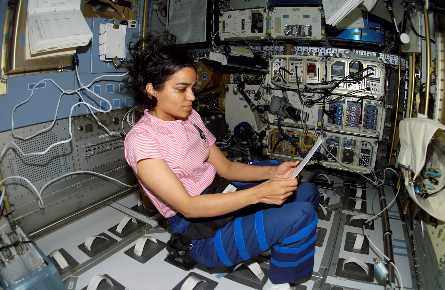 NASA astronaut Kalpana Chawla looks over a procedures checklist in the SPACEHAB Research Double Module aboard the Space Shuttle Columbia, on Jan. 27, 2003.