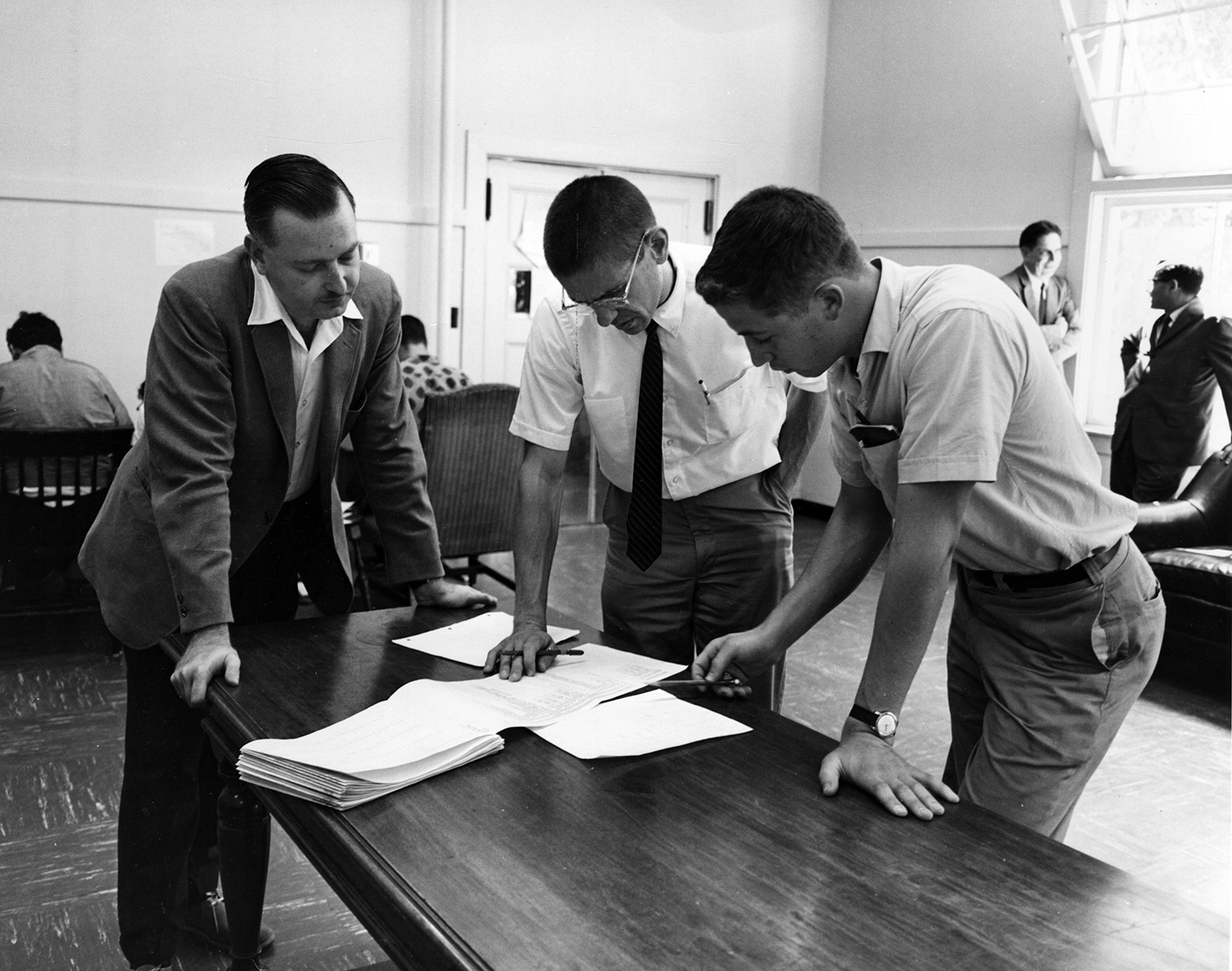 Early in BASIC's history, its creators, John Kemeny (left) and Thomas Kurtz (center) go over a program with a Dartmouth student (Adrian N. Bouchard / Dartmouth University)