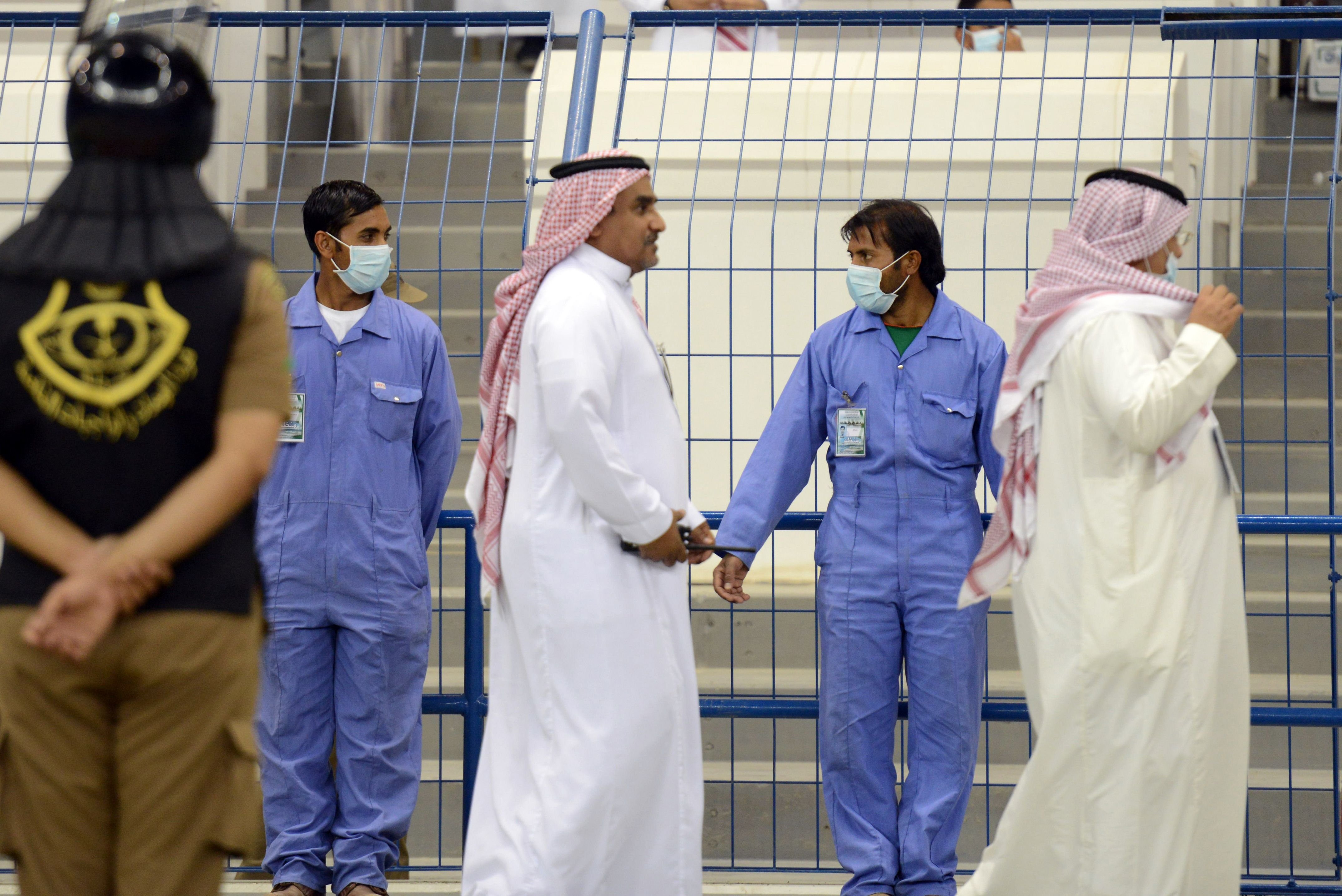 Asian workers wear mouth and nose masks while on duty during a football match at the King Fahad stadium, on April 22, 2014 in Riyadh. The health ministry reported more MERS cases in the city of Jeddah, prompting authorities to close the emergency department at the city's King Fahd Hospital. (Fayez Nureldine—AFP/Getty Images)