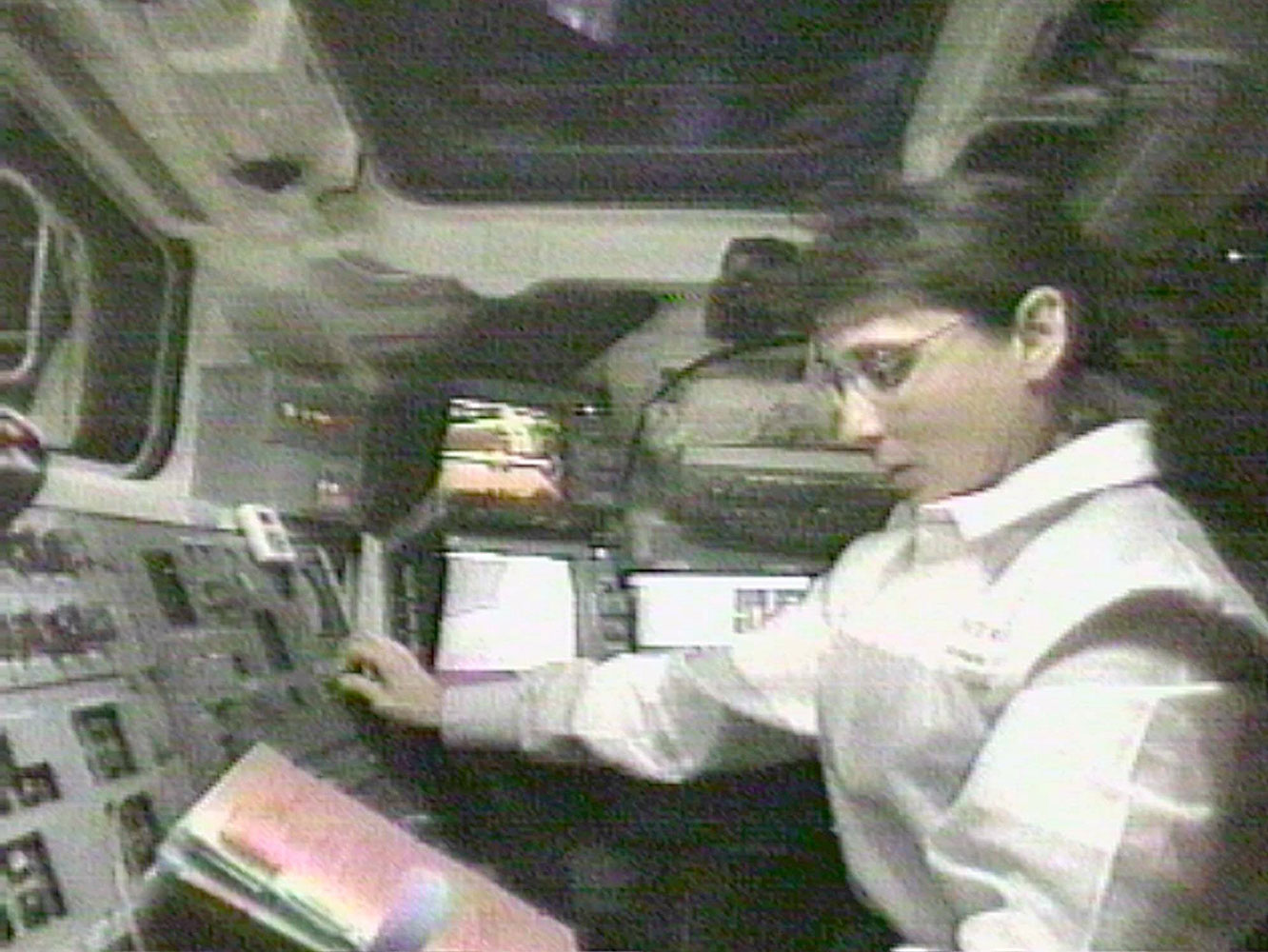 NASA Astronaut Nancy Currie reads a manual as she grapples an arriving space station module, in the cargo bay of the Endeavour, on Dec. 6, 1998.
