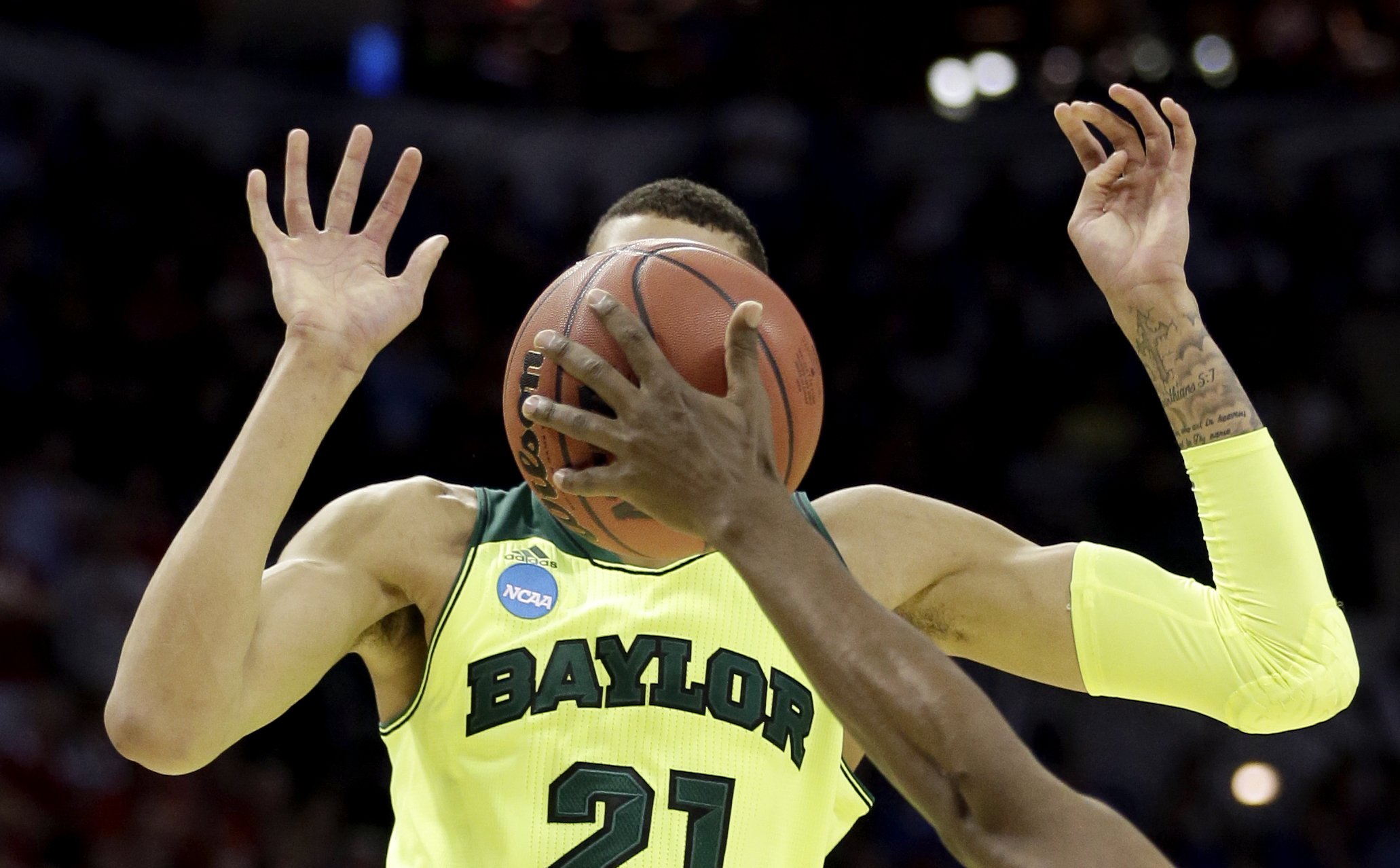 Baylor's Isaiah Austin has his face covered by the ball as Nebraska's Leslee Smith's arm reaches for the ball during the second half of a second-round game in the NCAA college basketball tournament, March 21, 2014, in San Antonio. Baylor won 74-60.