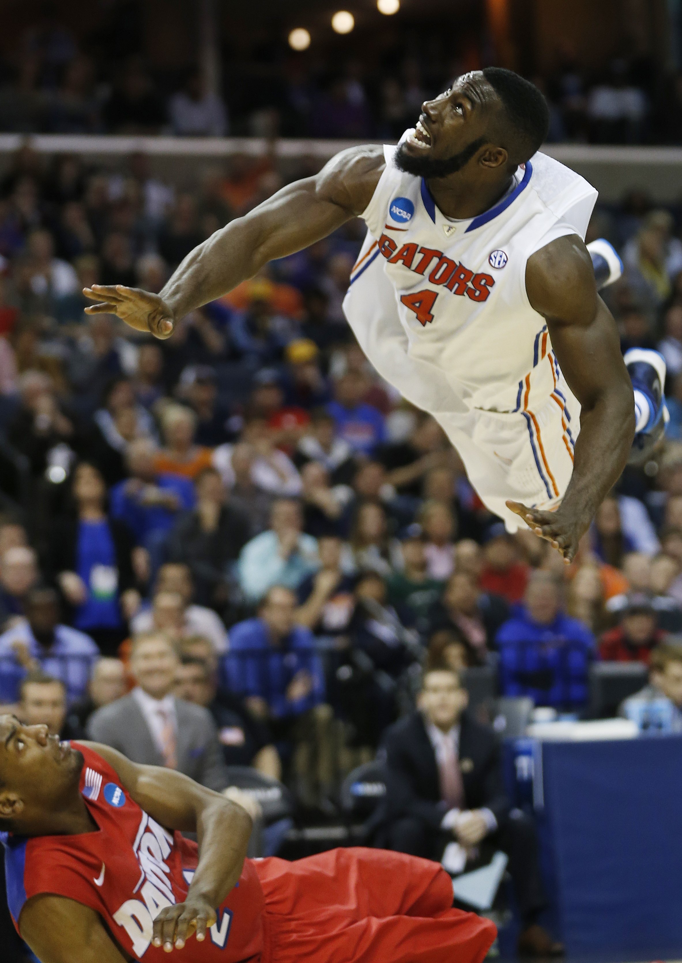 Florida center Patric Young watches his shot as Dayton forward Dyshawn Pierre falls to the floor during the second half in a regional final game at the NCAA college basketball tournament, March 29, 2014, in Memphis, Tenn.