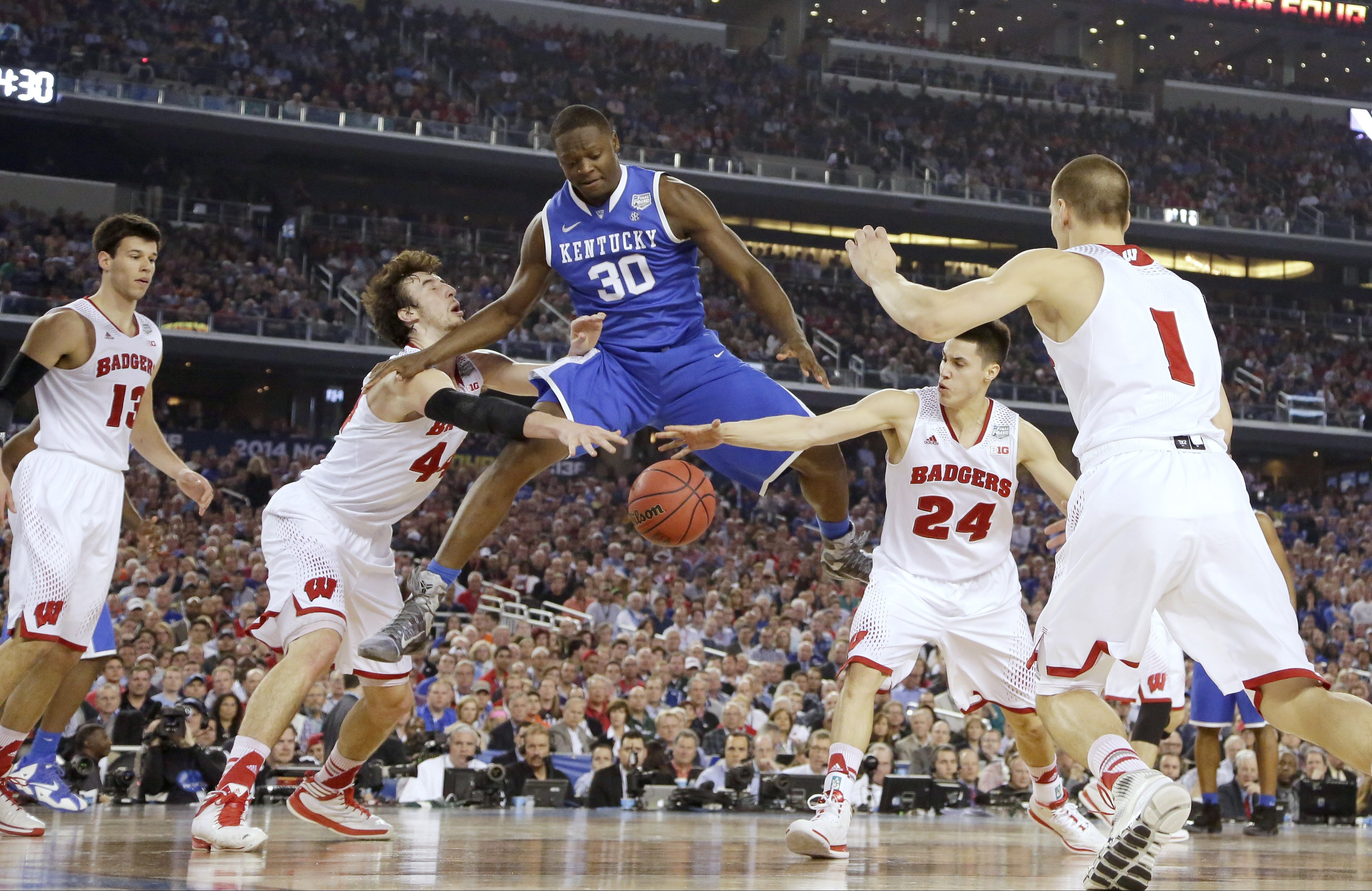 Kentucky forward Julius Randle loses the ball as, from left, Wisconsin forward Frank Kaminsky, guard Bronson Koenig and Ben Brust defend during the first half of the NCAA Final Four tournament college basketball semifinal game, April 5, 2014, in Arlington, Texas.