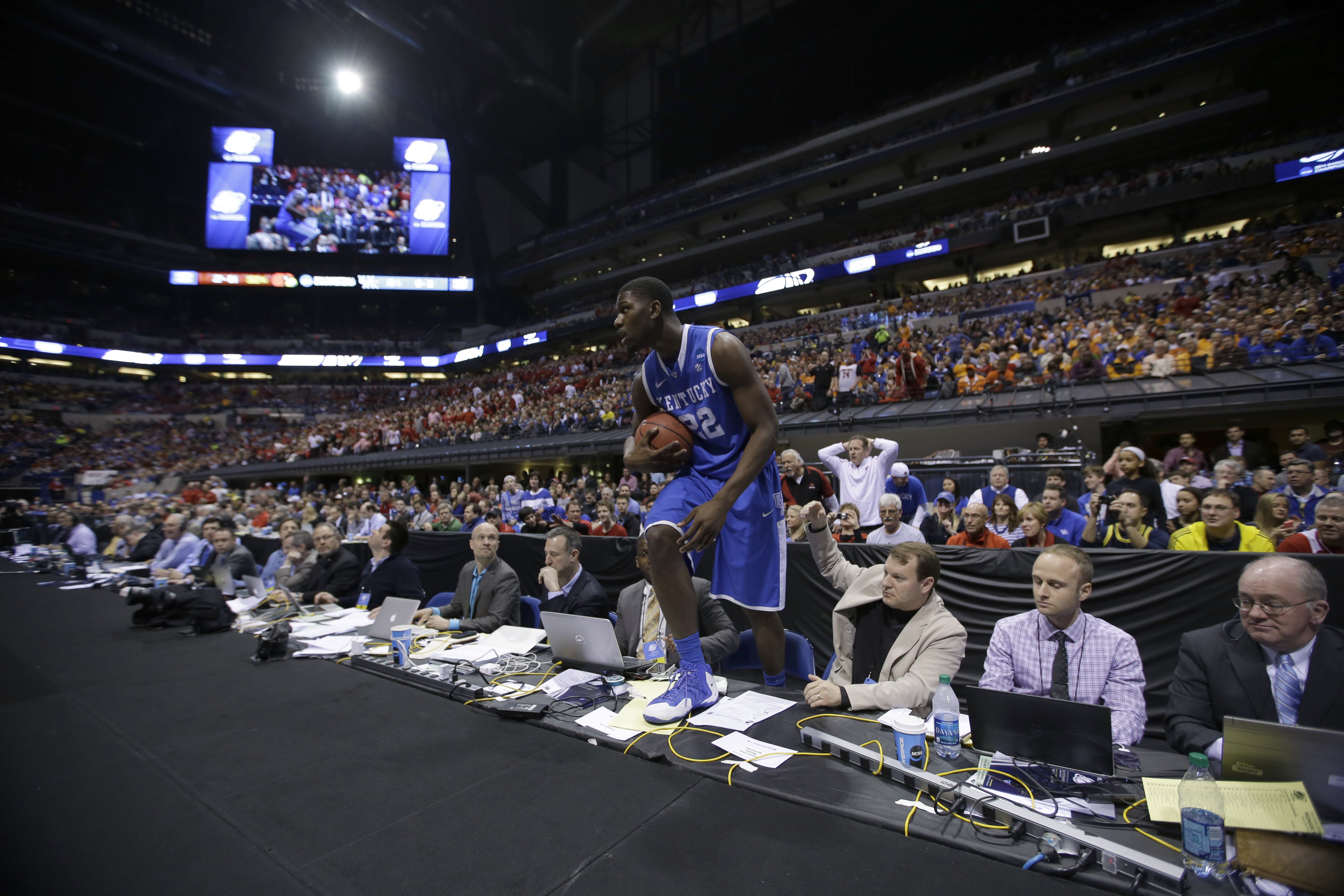 Kentucky forward Alex Poythress climbs back up to the court during the first half of an NCAA Midwest Regional semifinal college basketball tournament game against the Louisville, March 28, 2014, in Indianapolis.