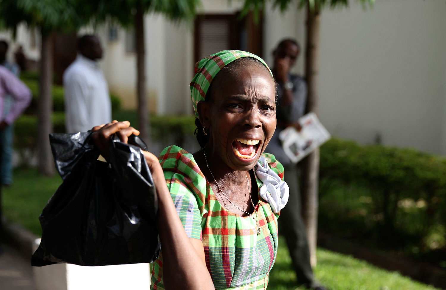 A bystander reacts as she sees victims of a bomb blast arriving at the Asokoro General Hospital in Abuja, April 14, 2014.