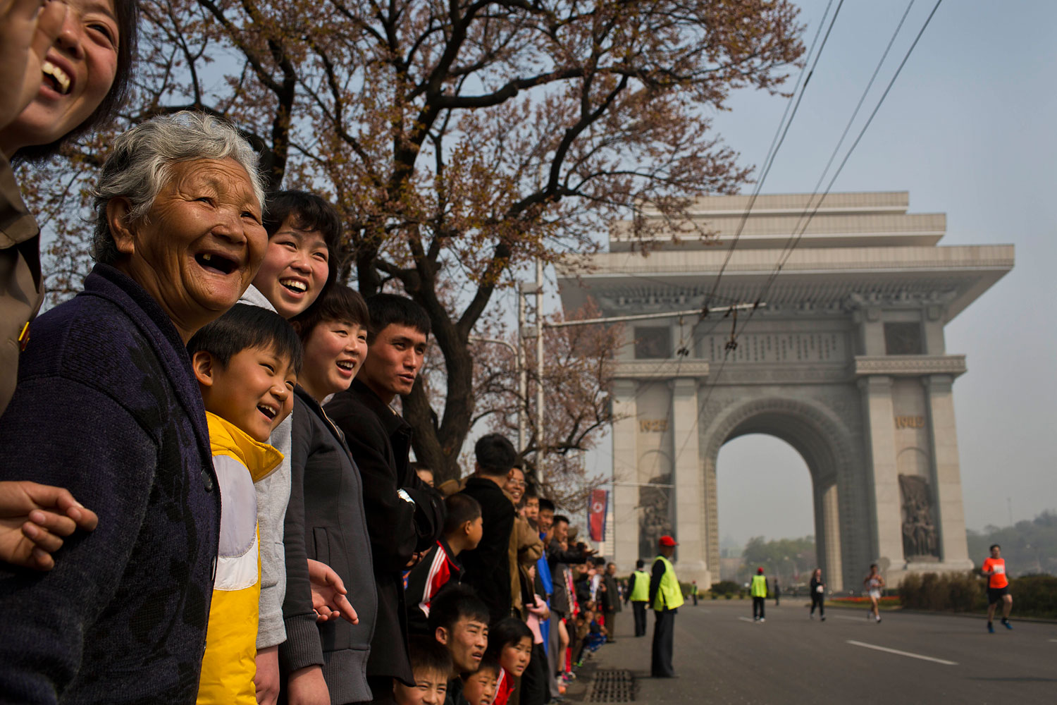 North Korean spectators watch from the roadside in central Pyongyang as runners pass by during the Mangyongdae Prize International Marathon in Pyongyang, April 13, 2014.