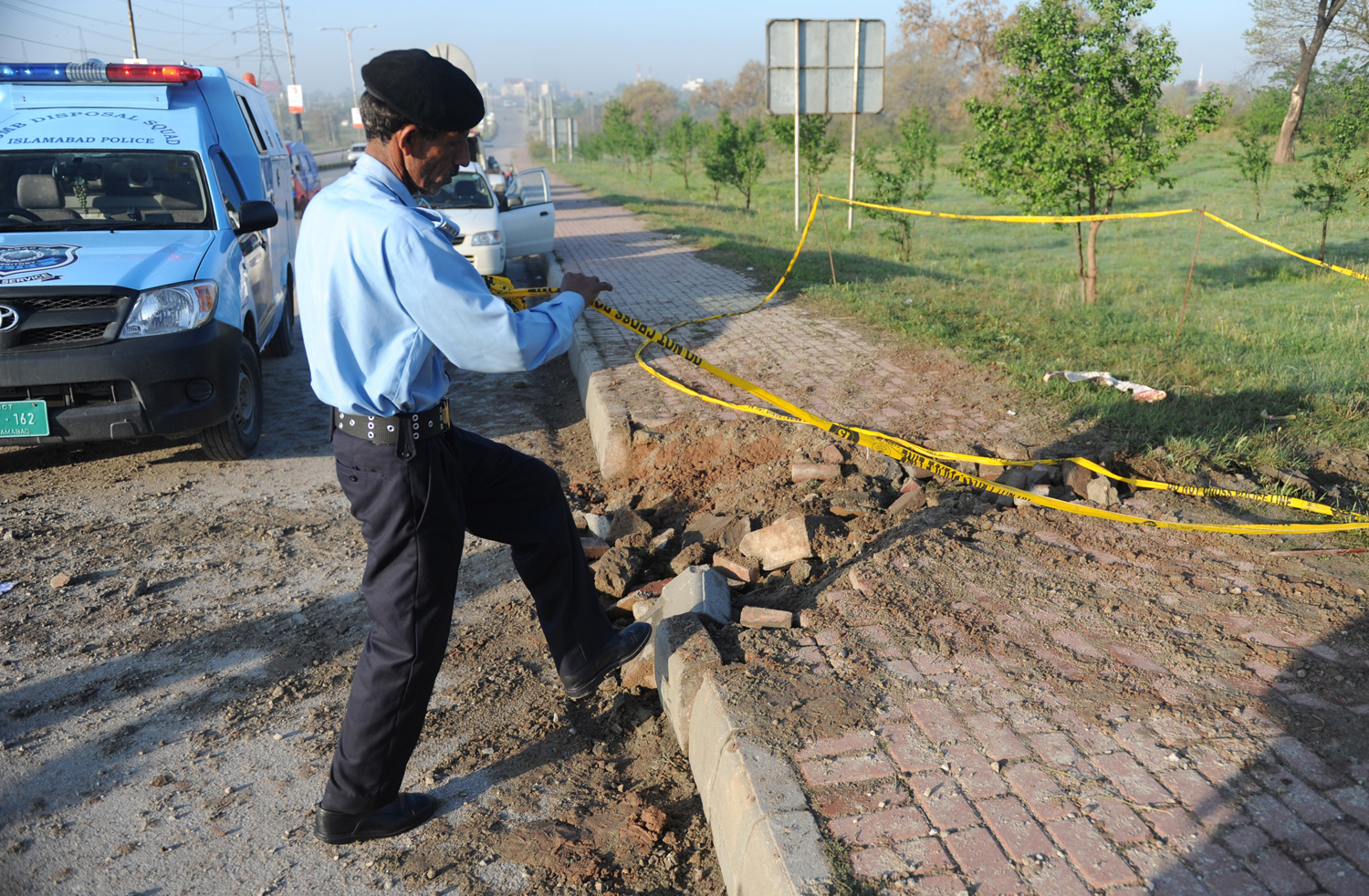 A Pakistani policeman rolls barricade tape at the site of a bomb explosion in Islamabad on April 3, 2014. (Aamir Qureshi - AFP/Getty Images)