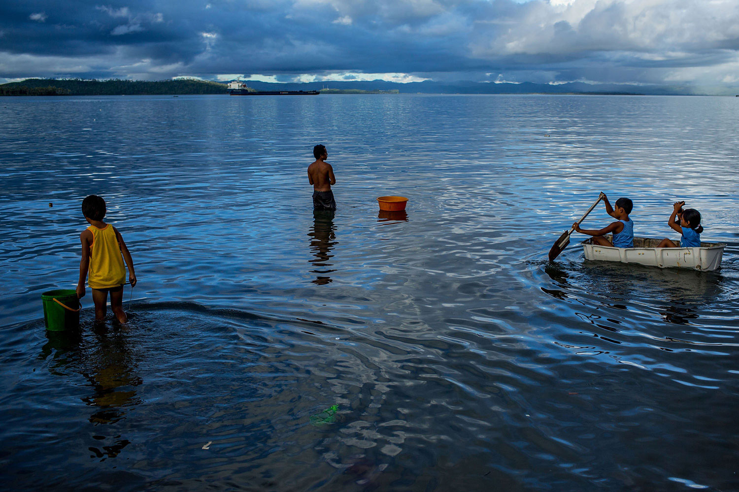 People enjoy the water off the coast of a destroyed town on April 18, 2014 in Tacloban.