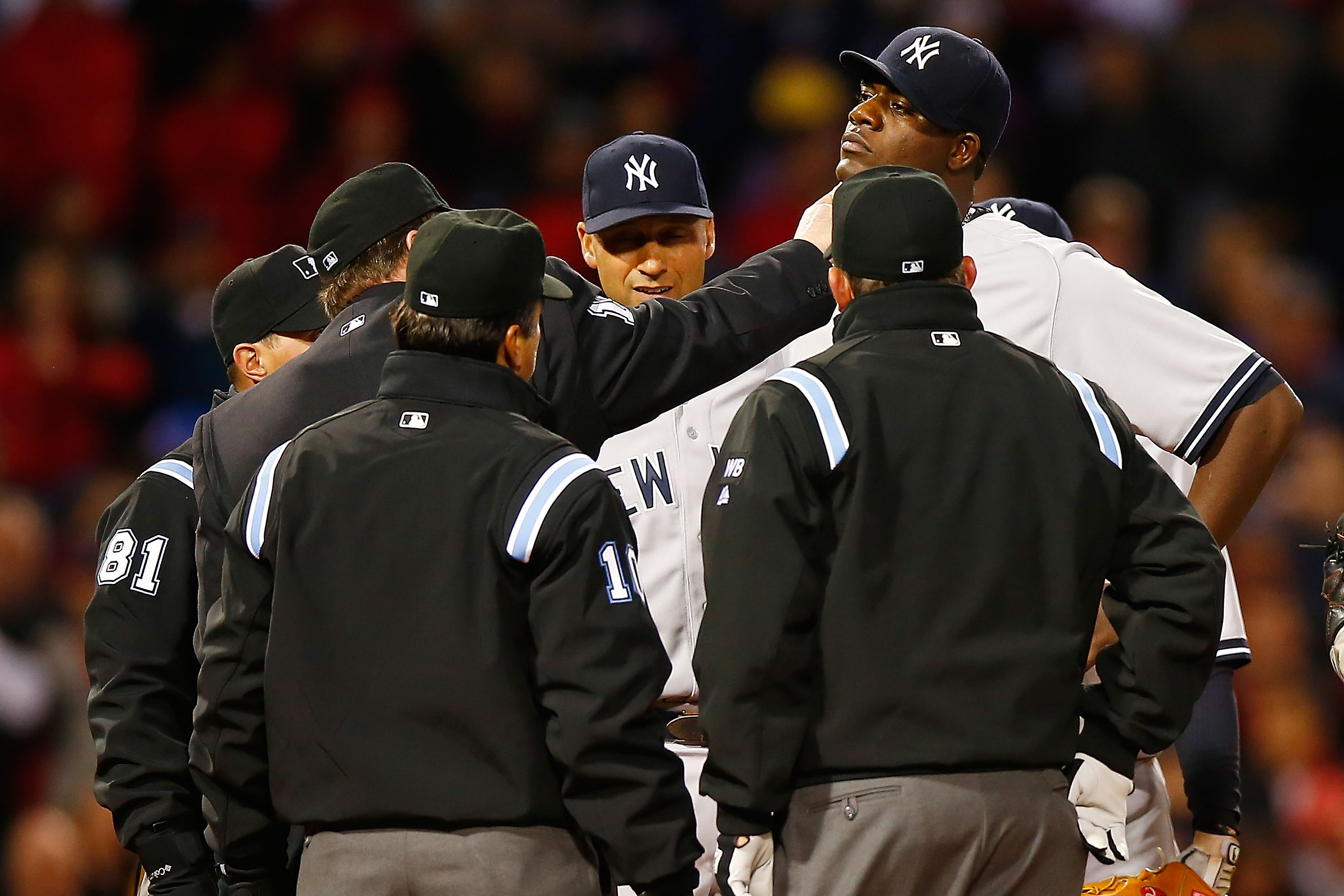 Home plate umpire Gerry Davis checks out a substance on the neck of Michael Pineda as New York Yankees shortstop Derek Jeter looks on. (Jared Wickerham&mdash;Getty Images)
