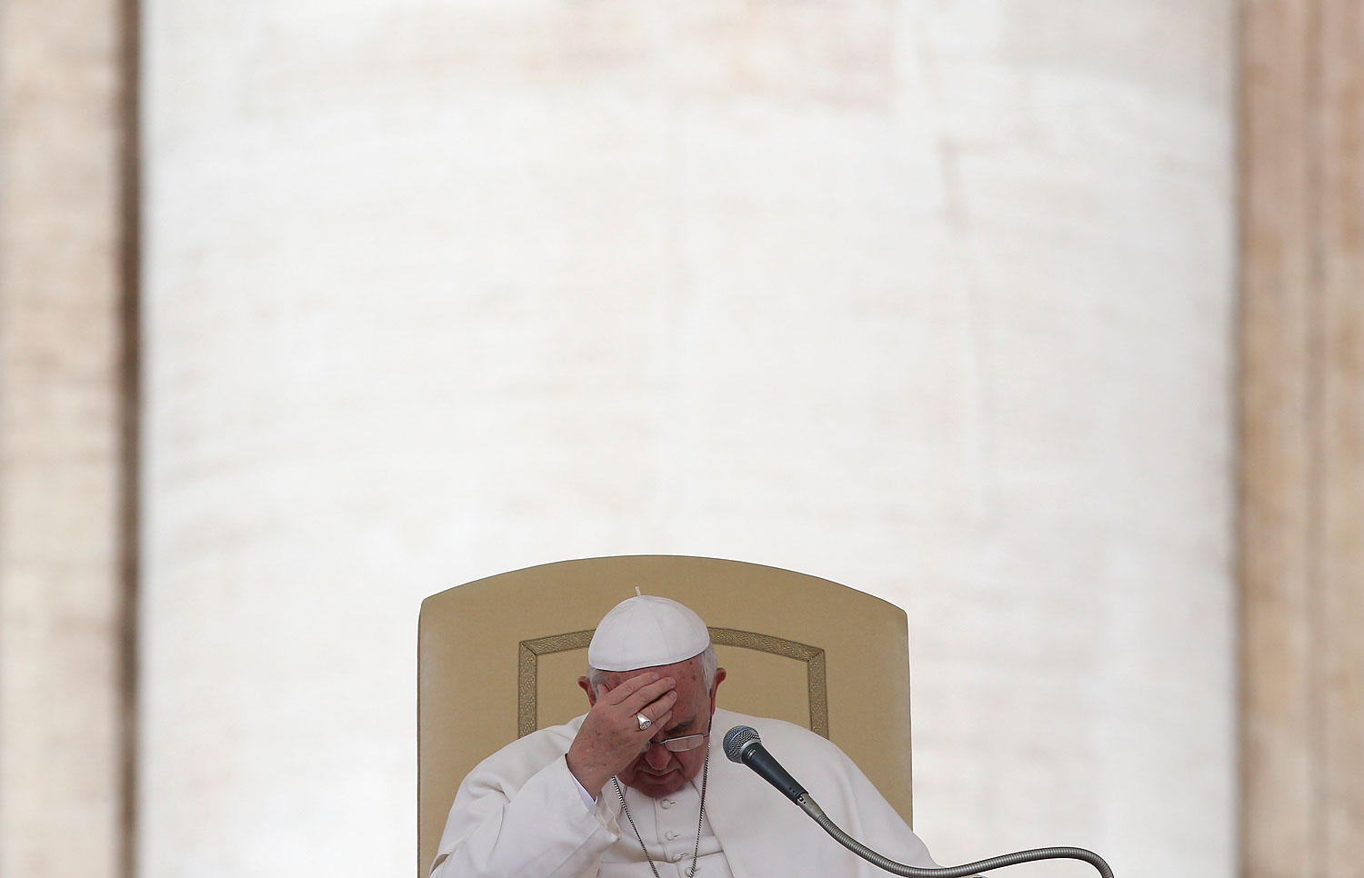 Pope Francis touches his forehead as he leads the general audience in Saint Peter's square at the Vatican, April 9, 2014.