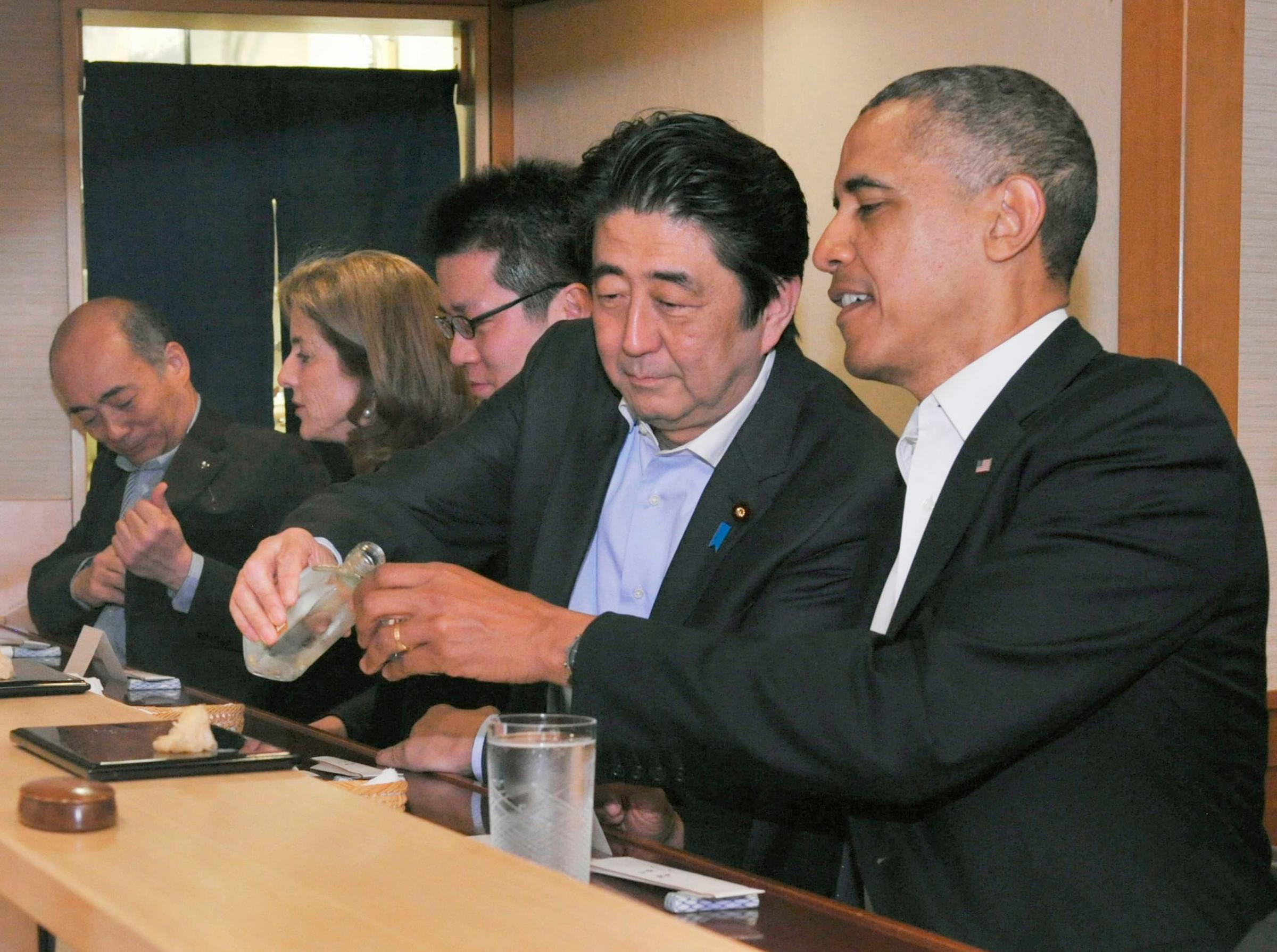 From left: Japan's Prime Minister Shizo Abe fills the glass of U.S. President Barak Obama during a dinner at Sukiyabashi Jiro sushi restaurant in Tokyo's Ginza district on April 23, 2014.