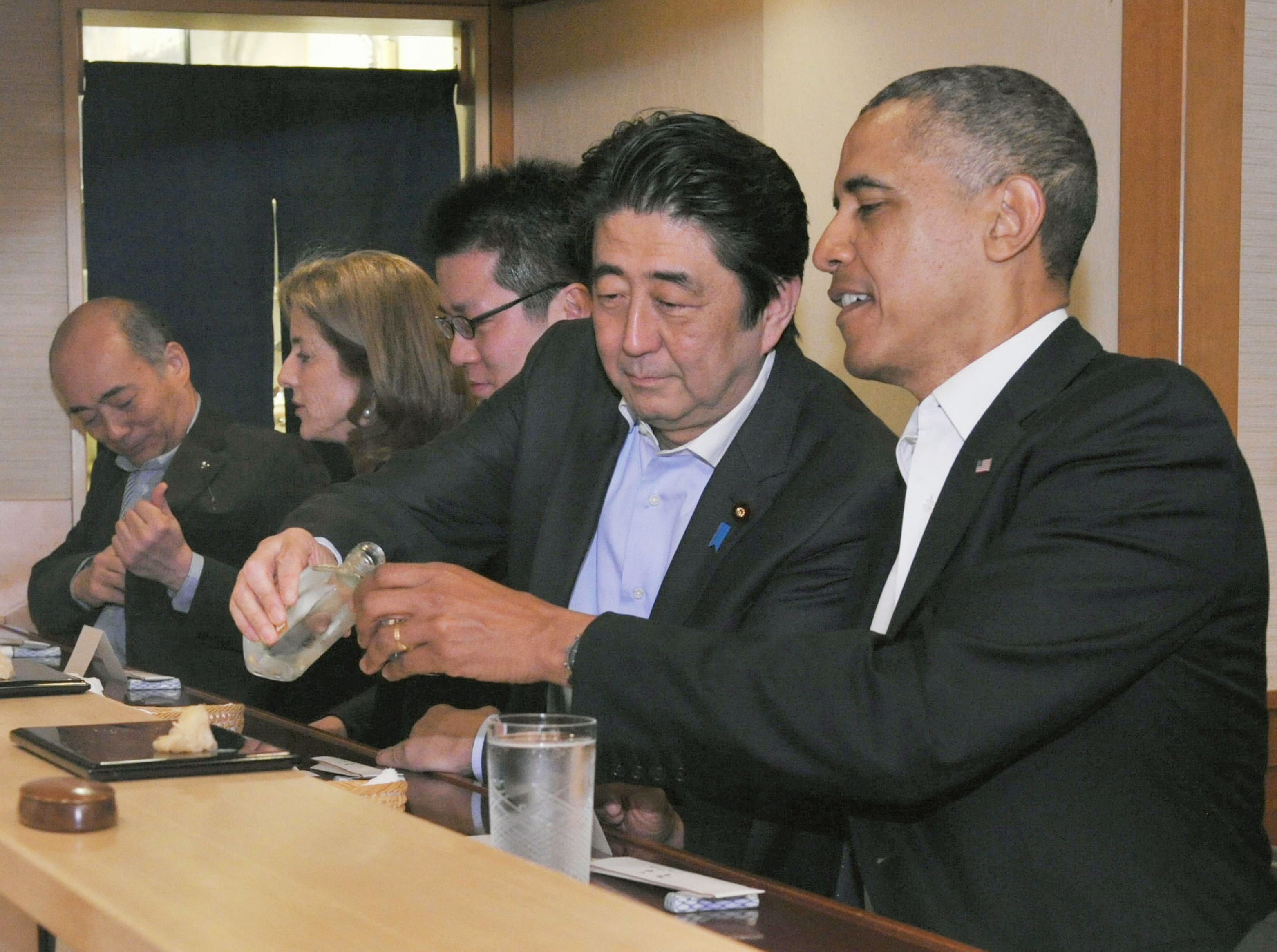 From left: Japan's Prime Minister Shizo Abe fills the glass of U.S. President Barak Obama during a dinner at Sukiyabashi Jiro sushi restaurant in Tokyo's Ginza district on April 23, 2014. (Japan's Cabinet Public Relations Office/Kyodo/Reuters)