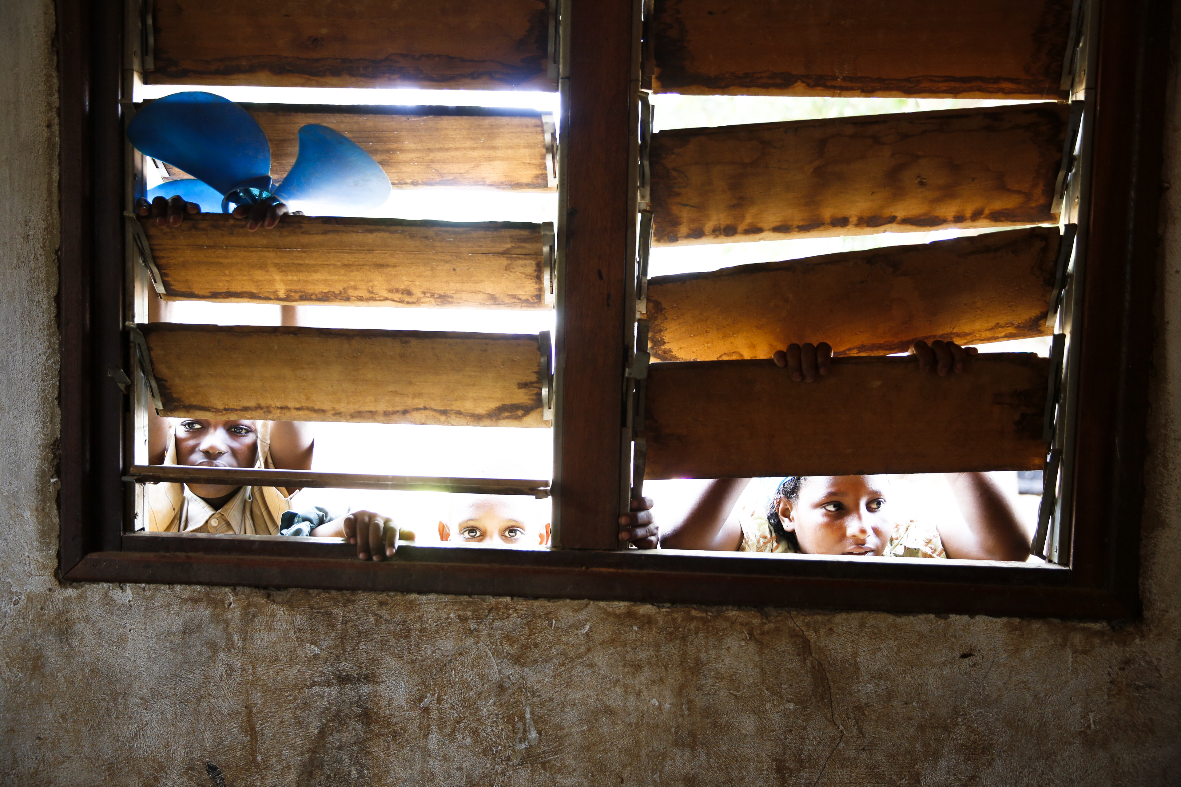 Mar. 27, 2014. Children peer through the blinds of a back room of the mosque in the Muslim enclave of Begoua, in the PK12 area, on the day that aid workers document malnourished children. Some 2,000 Muslims, mostly Peuhl, have taken refuge at the mosque. In PK12, there is limited access to food and medical care.