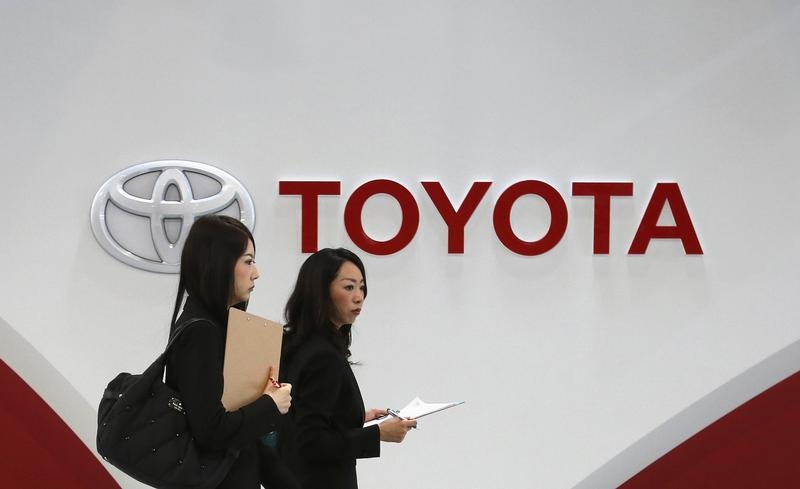 Women walk in front of Toyota Motor's logo at the company's showroom in Tokyo
