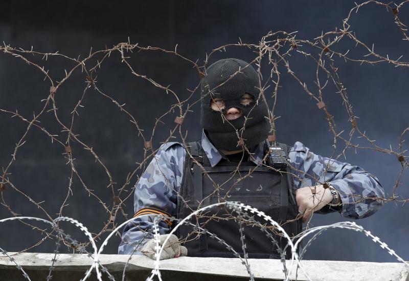 A pro-Russia protester stands at a barricade outside a regional government building in Donetsk
