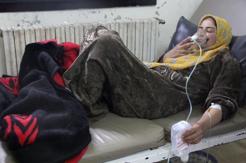 A woman breathes through an oxygen mask inside a field hospital in Kfar Zeita village in the central province of Hama