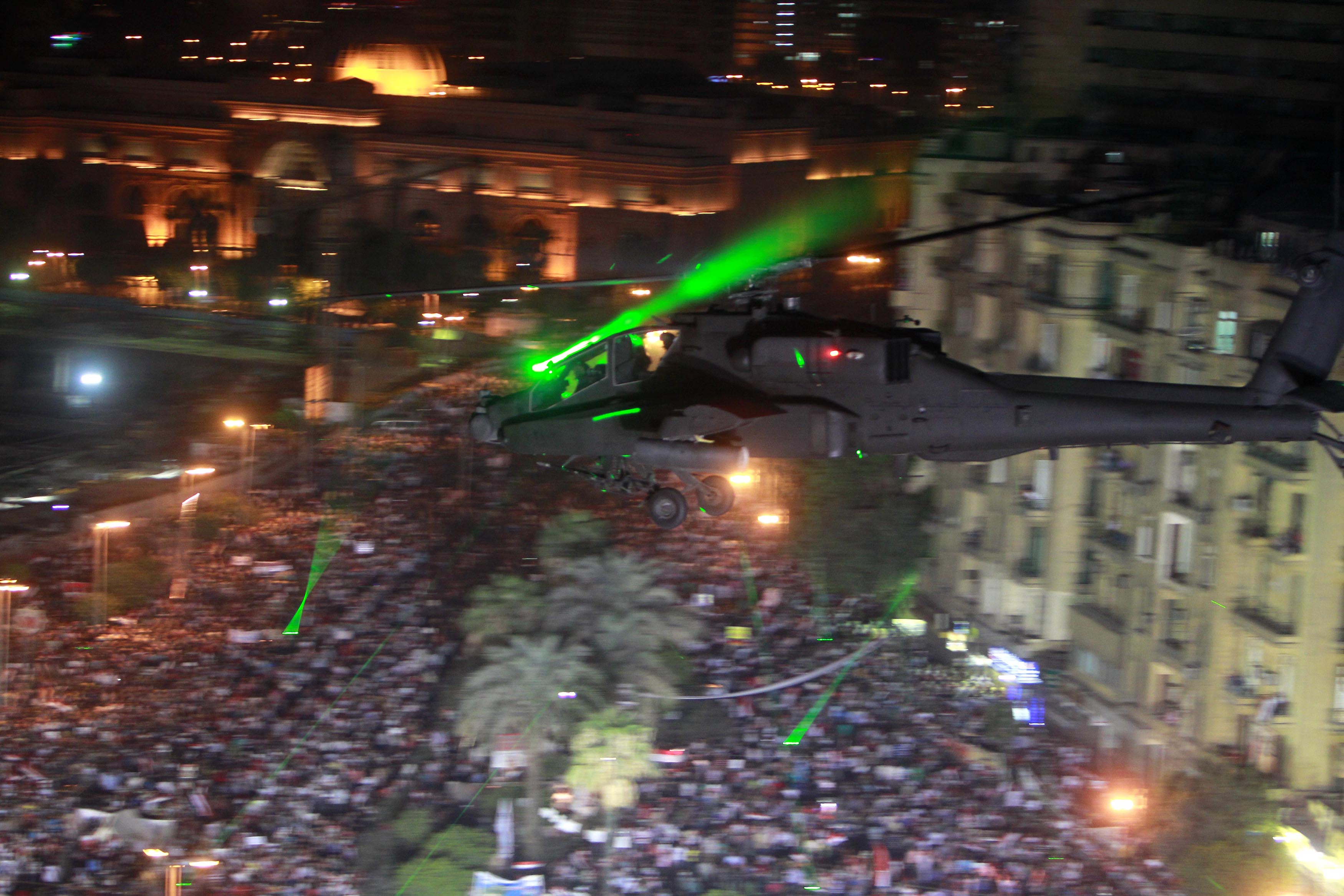 An Apache helicopter flies over Tahrir Square during a protest to support the army in Tahrir square in Cairo