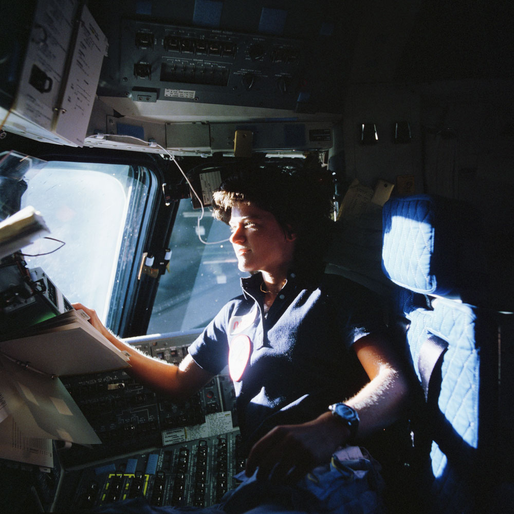 NASA Astronaut Sally K. Ride, STS-7 mission specialist, communicates with ground controllers from the flight deck of the Earth-orbiting Space Shuttle Challenger at an unknown location, on June 21, 1983. Ride was America's first woman in space.