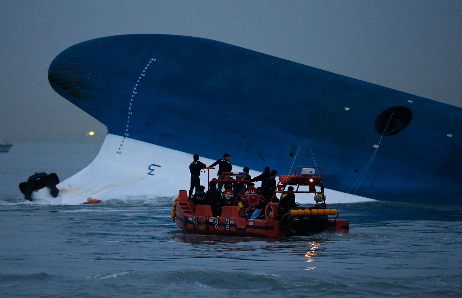 Maritime police search for missing passengers in front of the South Korean ferry Sewol which sank at the sea off Jindo April 16, 2014.