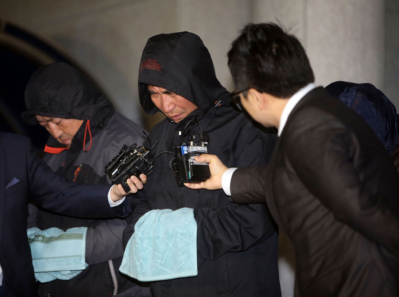 Journalists ask Lee Joon-seok, captain of South Korean ferry Sewol which sank at sea off Jindo, questions as Lee walked out of court after an investigation in Mokpo April 19, 2014.