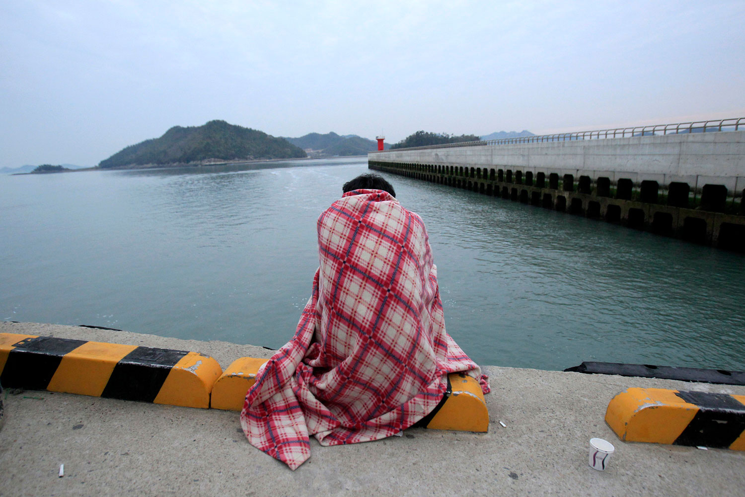 A relative waits for their missing loved one at a port in Jindo, South Korea, April 16, 2014 following the capsizing of the South Korean ferry Sewol.