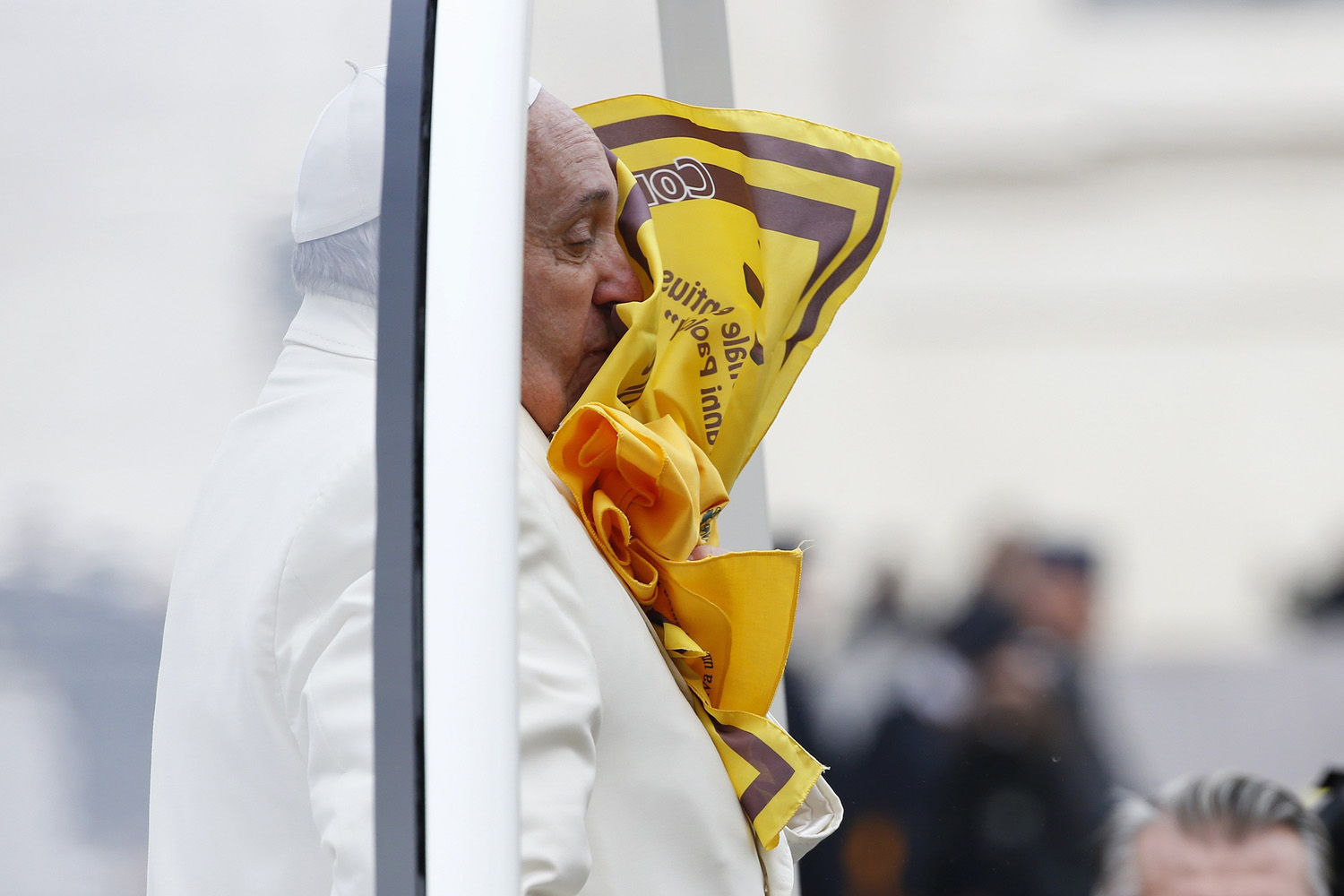 A scarf thrown by faithful is seen on the face of Pope Francis during the general audience in Saint Peter's Square at the Vatican