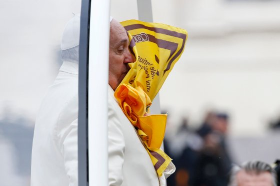 A scarf thrown by faithful is seen on the face of Pope Francis during the general audience in Saint Peter's Square at the Vatican