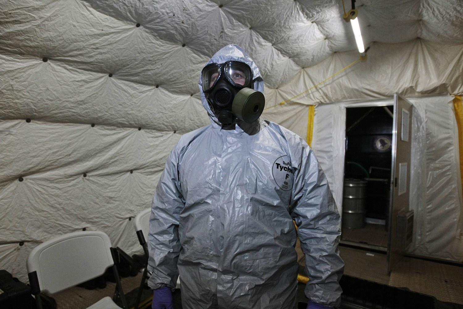 A marine officer of the Cape Ray, a ship equipped to neutralize Syrian chemicals, shows a chemical protection suit  to reporters during a tour around the ship docked at the naval base of Rota used by the U.S, in Spain’s southwestern coast on April 10, 2014. (Alfonso Perez—AP)