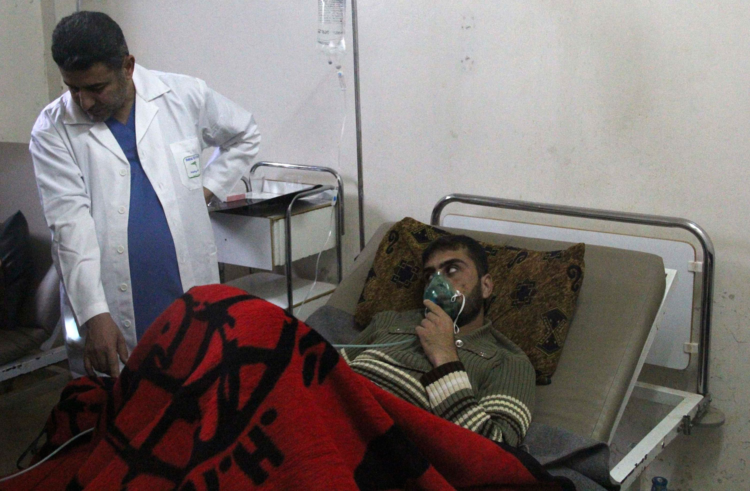 A man, affected by what activists say was a gas attack, breathes through an oxygen mask inside a field hospital in Kfar Zeita village in the central province of Hama, April 12, 2014. 