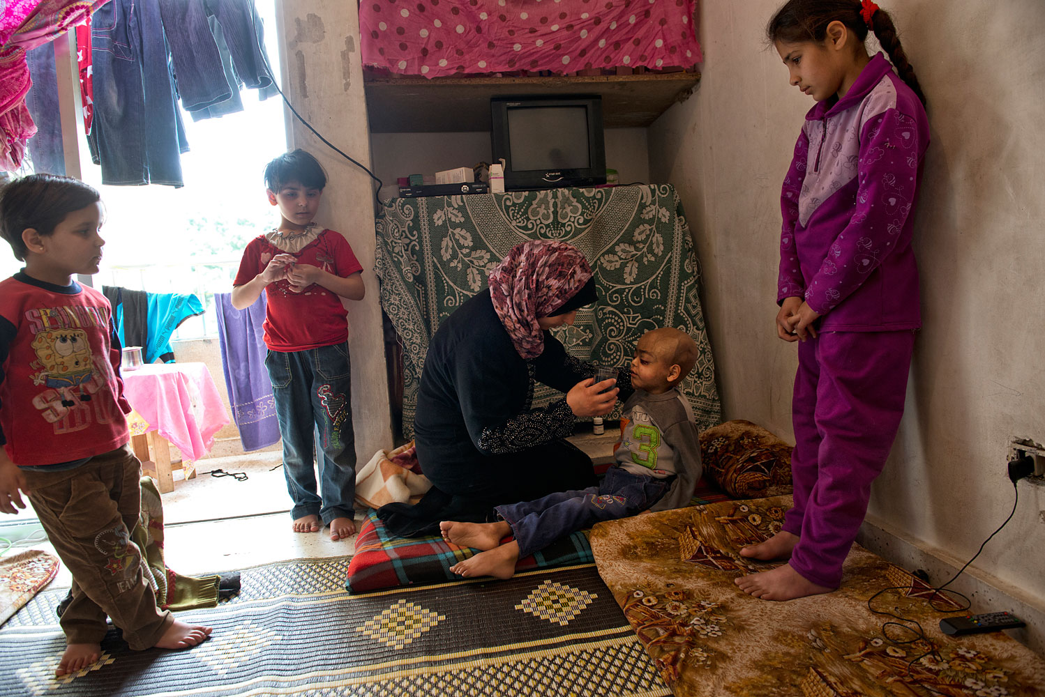 Feryal, 29, gives water to Zacharia, her four-year-old son, in the apartment they live in in Halat. He is dying of cancer. In Syria, the trip to hospital became too dangerous. “I was afraid,” said Feryal. By the time they reached Lebanon, the cancer had spread to his brain, she says, adding: “I failed him.”