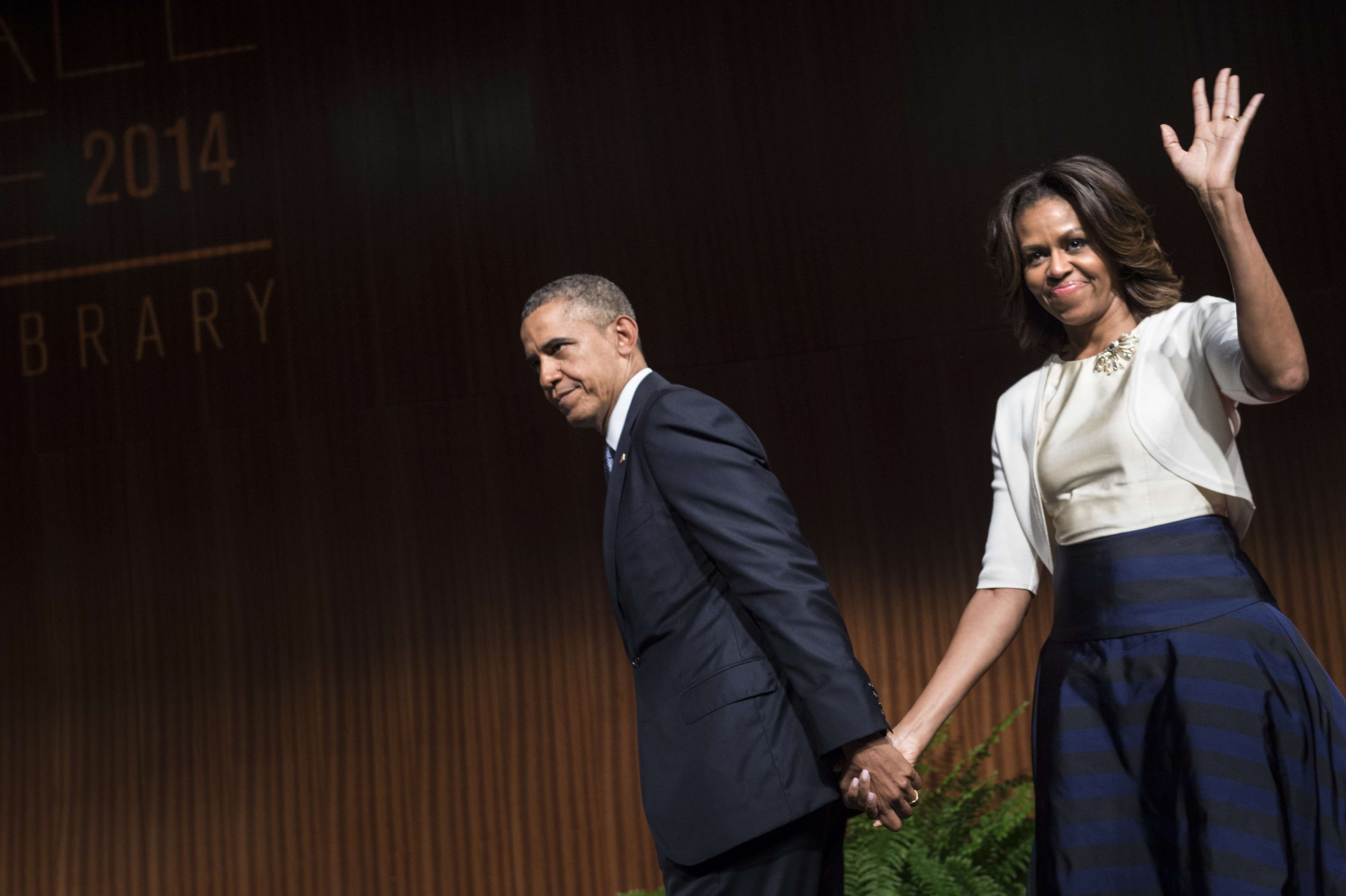 President Barack Obama leaves with first lady Michelle Obama after speaking at the Lyndon B. Johnson Presidential Library in Austin, Texas.