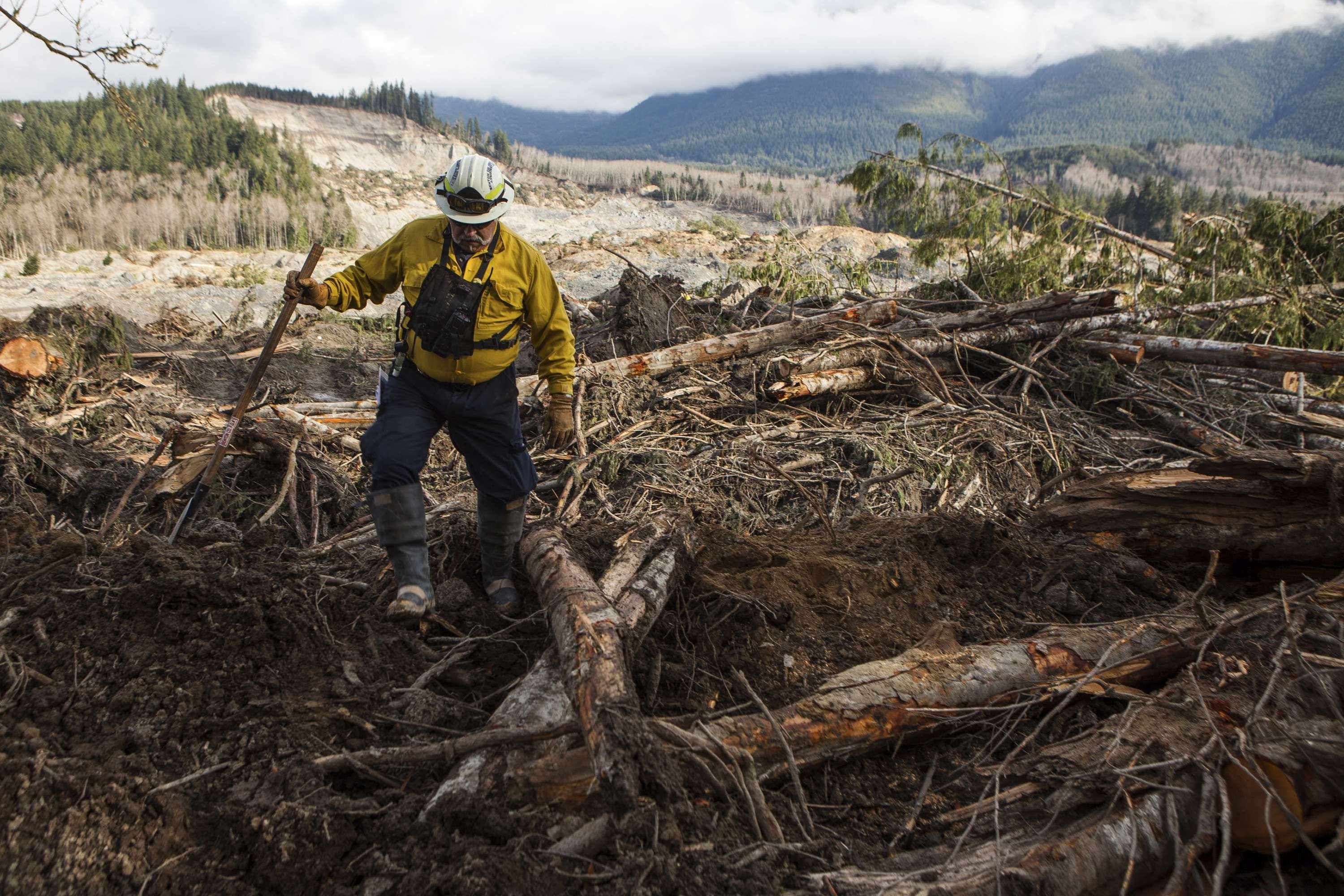 Benton County Assistant Fire Chief Jack Coats makes his way over debris left by a mudslide in Oso