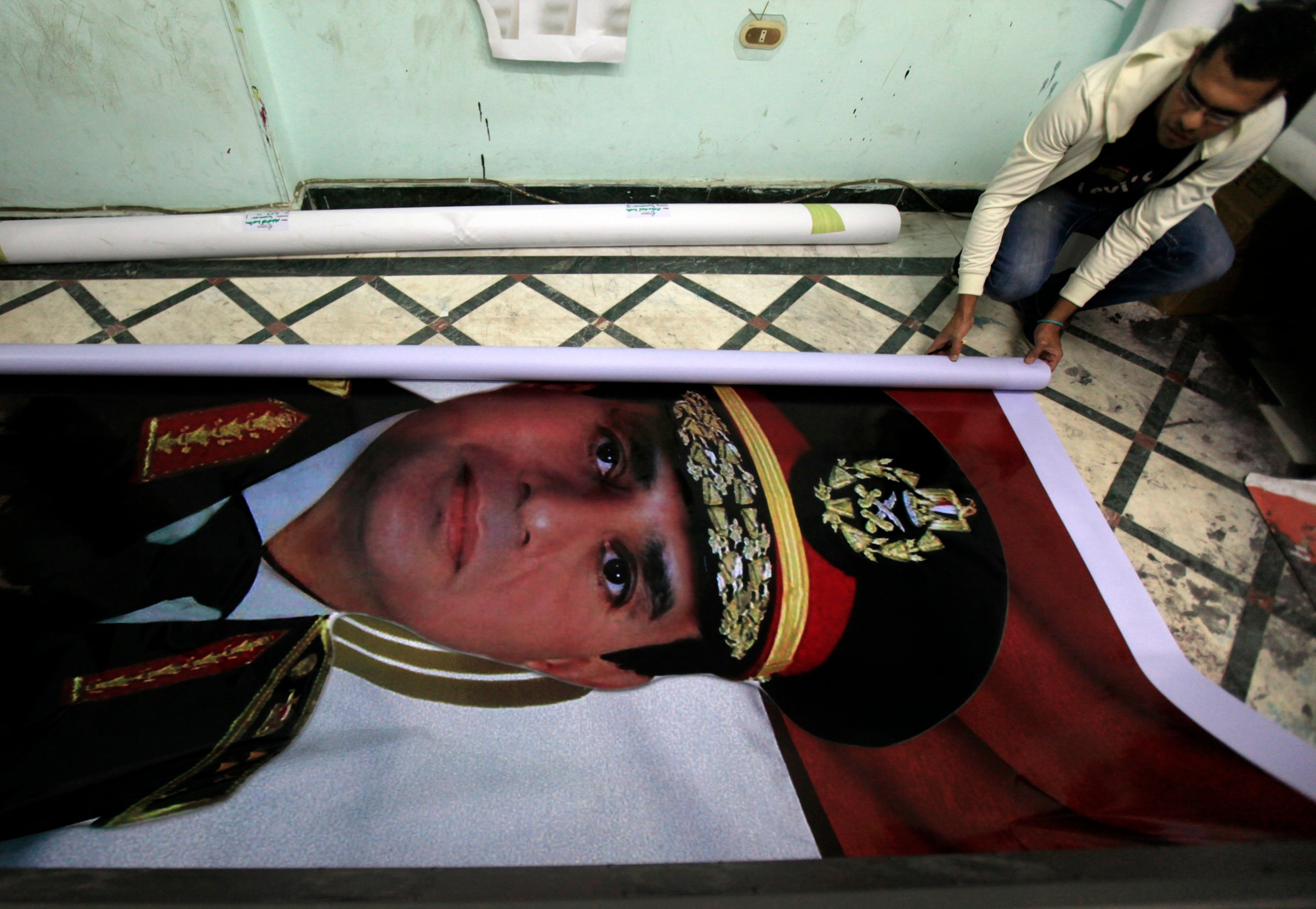 Eyes on the prize A printshop worker rolls up a poster of al-Sisi, who resigned as Egypts military chief in March in order to run for President
