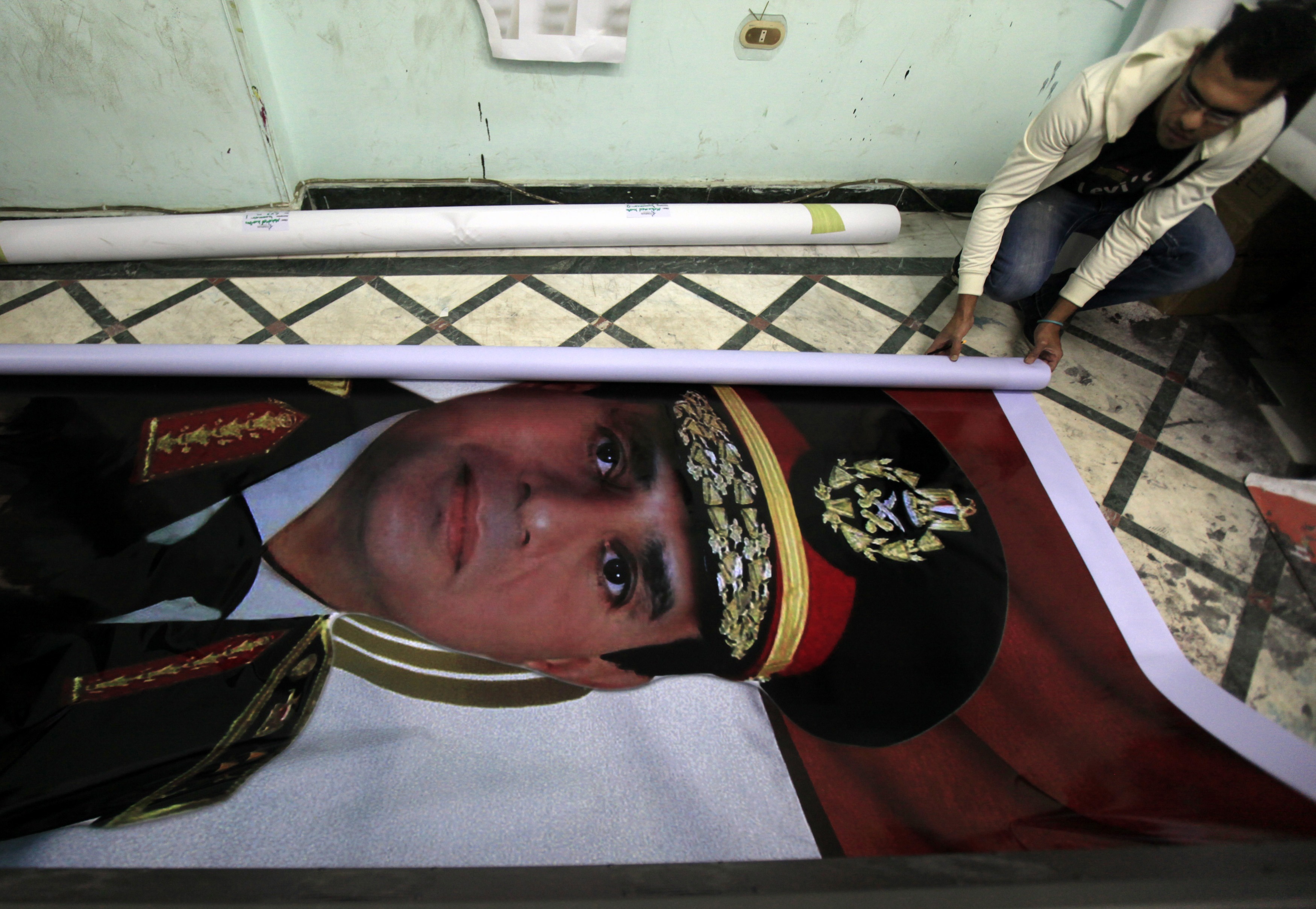 <strong>Eyes on the prize</strong> A printshop worker rolls up a poster of al-Sisi, who resigned as Egypt’s military chief in March in order to run for President (Amr Dalsh—Reuters)