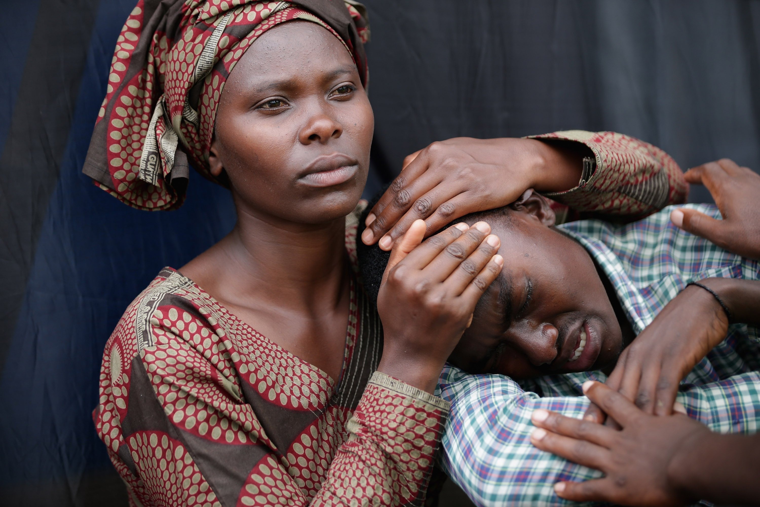 Rwandans impacted by the genocide comfort each other during a commemoration ceremony in Kigali, on April 7. (Chip Somodevilla—Getty Images)