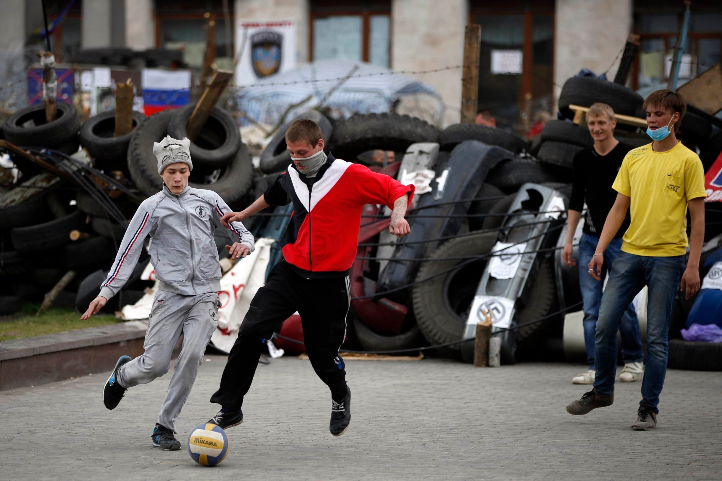 Pro-Russian protesters play soccer in front of a barricade outside a regional government building in Donetsk, eastern Ukraine April 19, 2014.