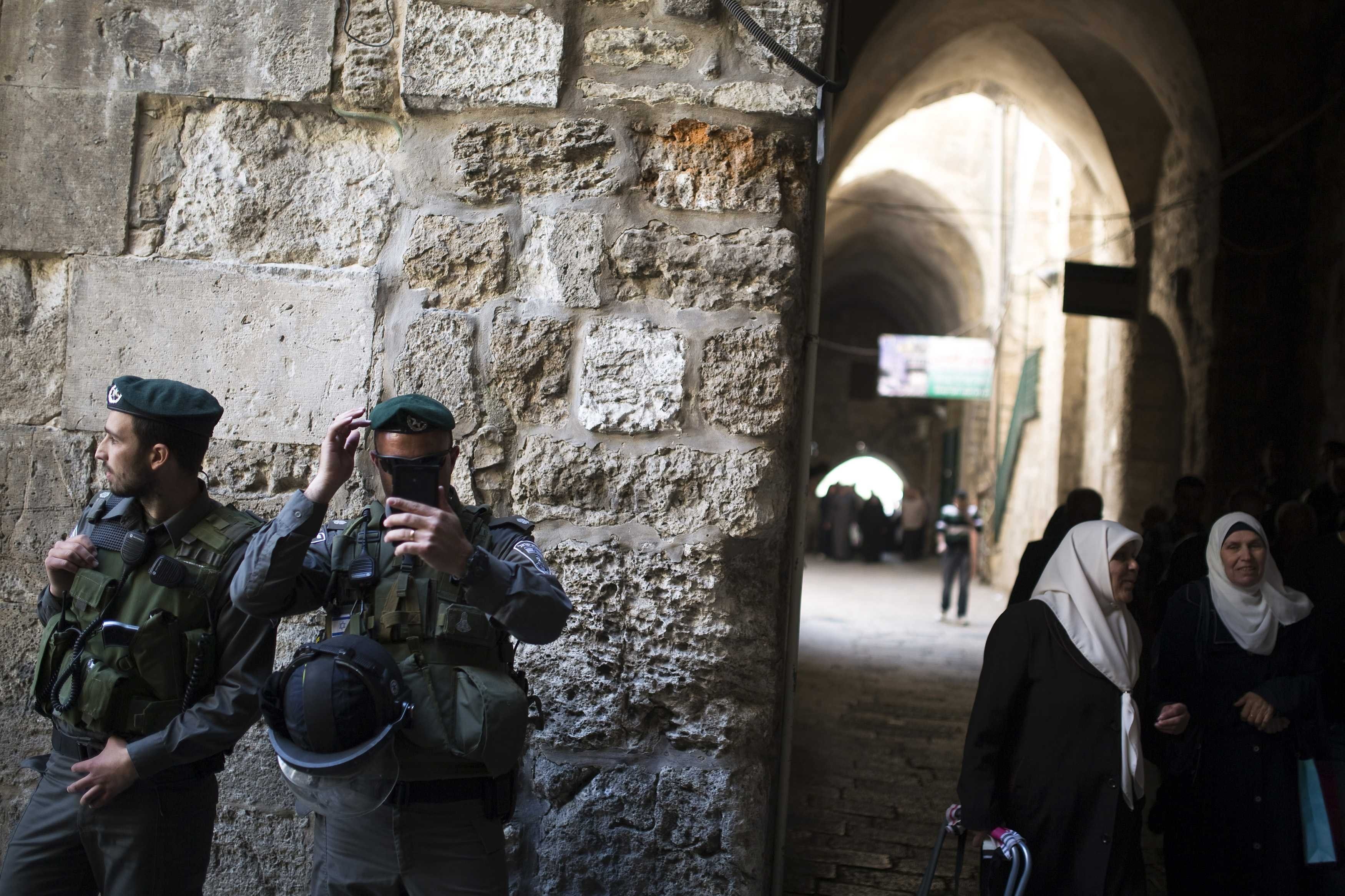 Palestinian women walk near Israeli border policemen after Friday prayers in Jerusalem's Old City April 4, 2014. (Amir Cohen—Reuters)