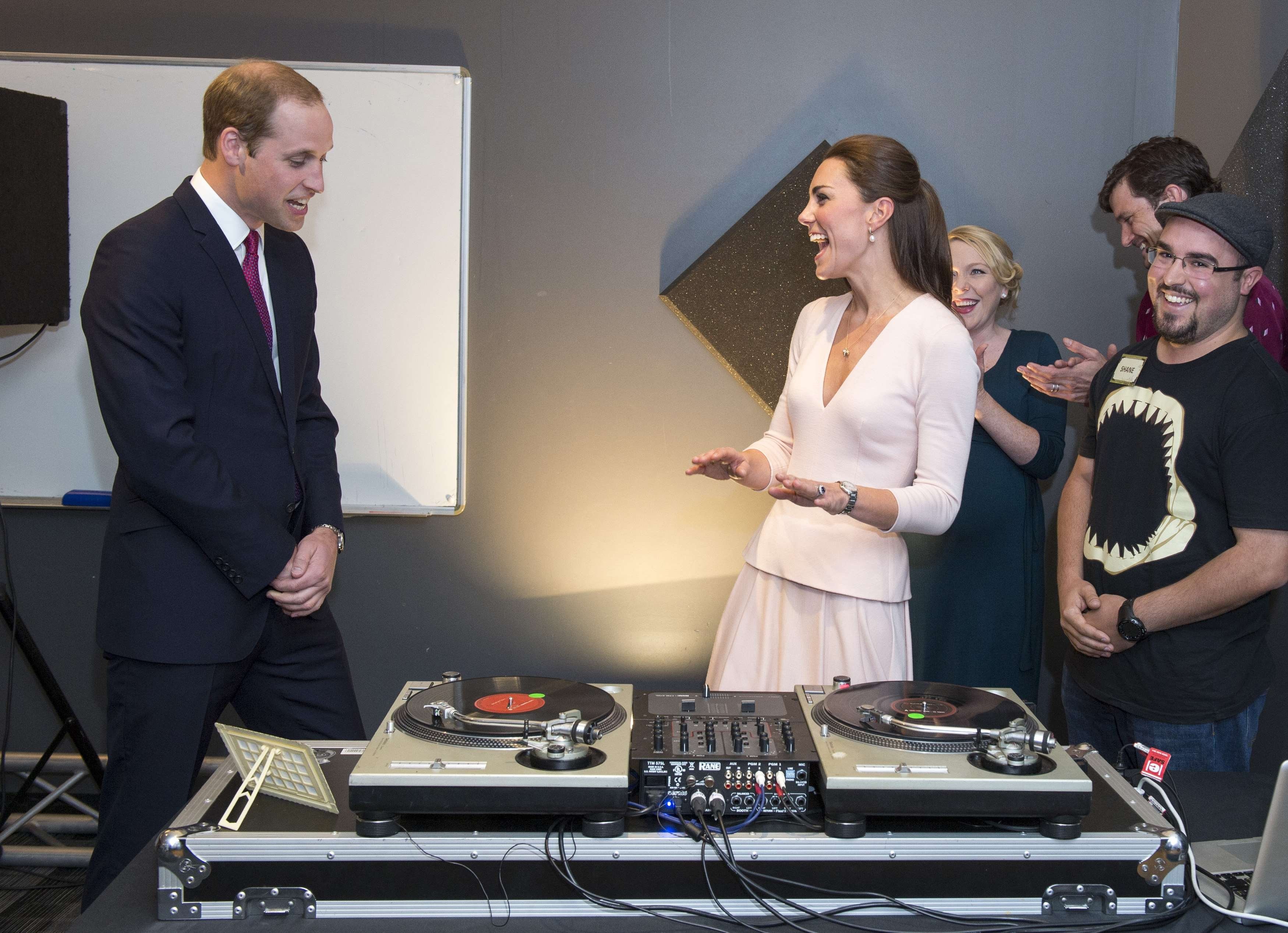 Britain's Catherine, Duchess of Cambridge (2nd R) gestures to her husband Prince William, as they play on DJ decks at the Northern Sound System in Elizabeth near Adelaide April 23, 2014. 