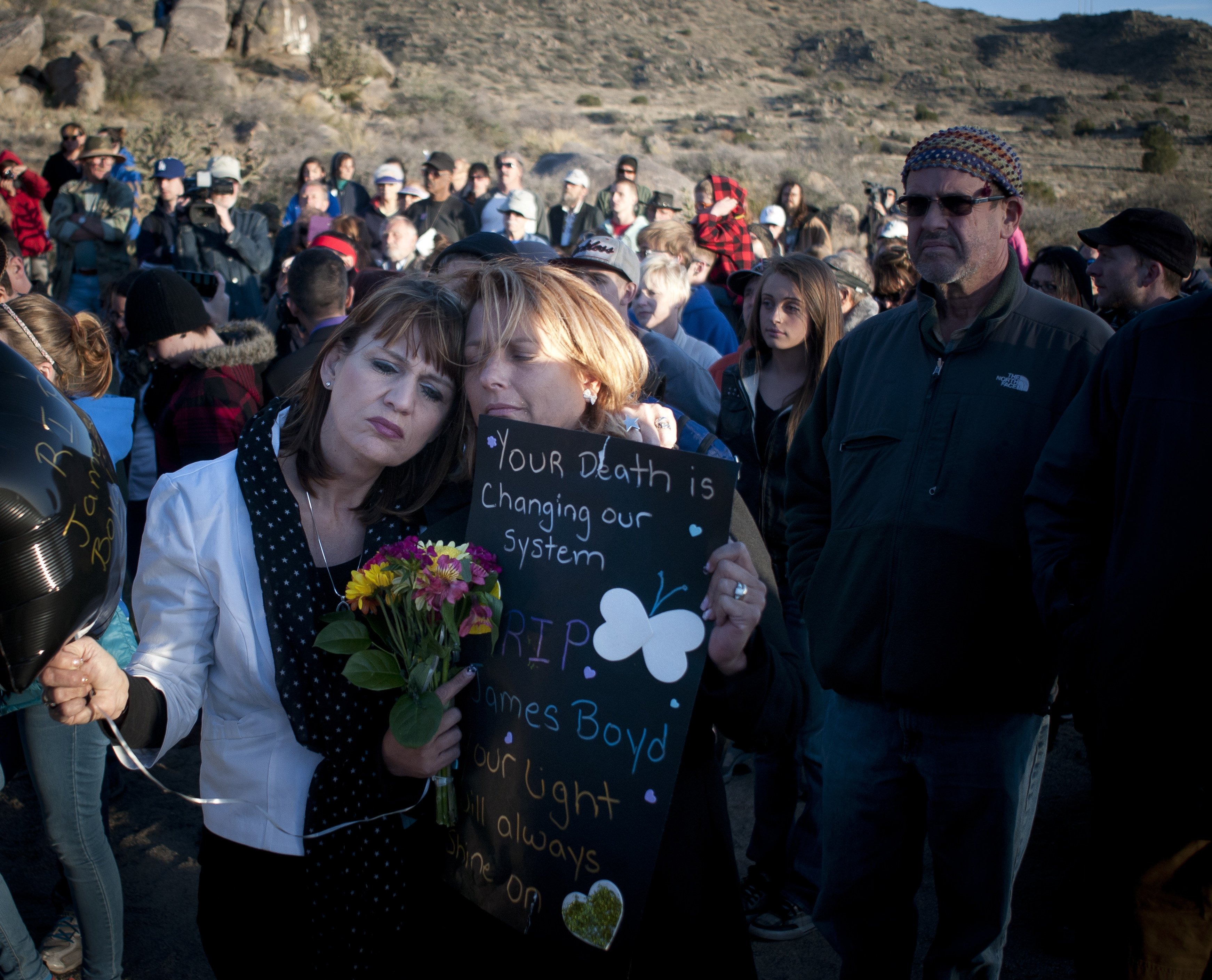 Star Garrett, left, and Shannon Haley, second from left, embrace during the vigil for James Boyd in the foothills near U-Mound in Albuquerque, April 2, 2014. (Marla Brose—Albuquerque Journal/ZUMA Press)