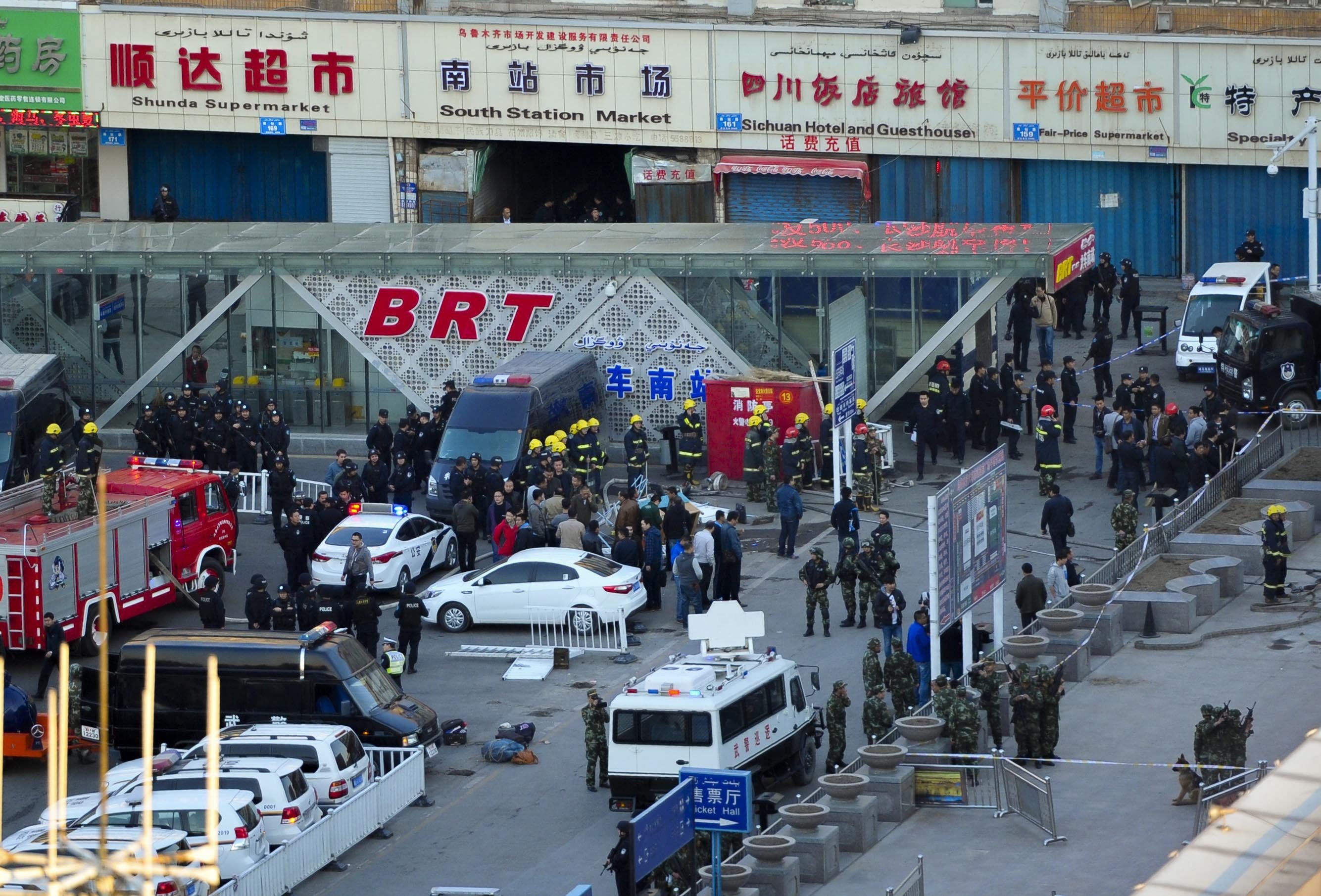 Security personnel inspect the explosion site outside Urumqi South Railway Station in Urumqi in northwest China's Xinjiang Uygur Autonomous Region, April 30, 2014 after an explosion that killed some people and injured some. 