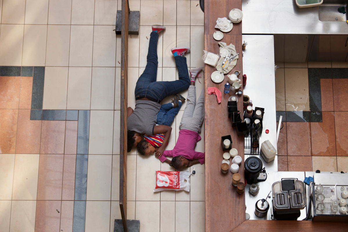 A woman and children hide inside Westgate Mall in Nairobi, Kenya, Sept. 21, 2013.
