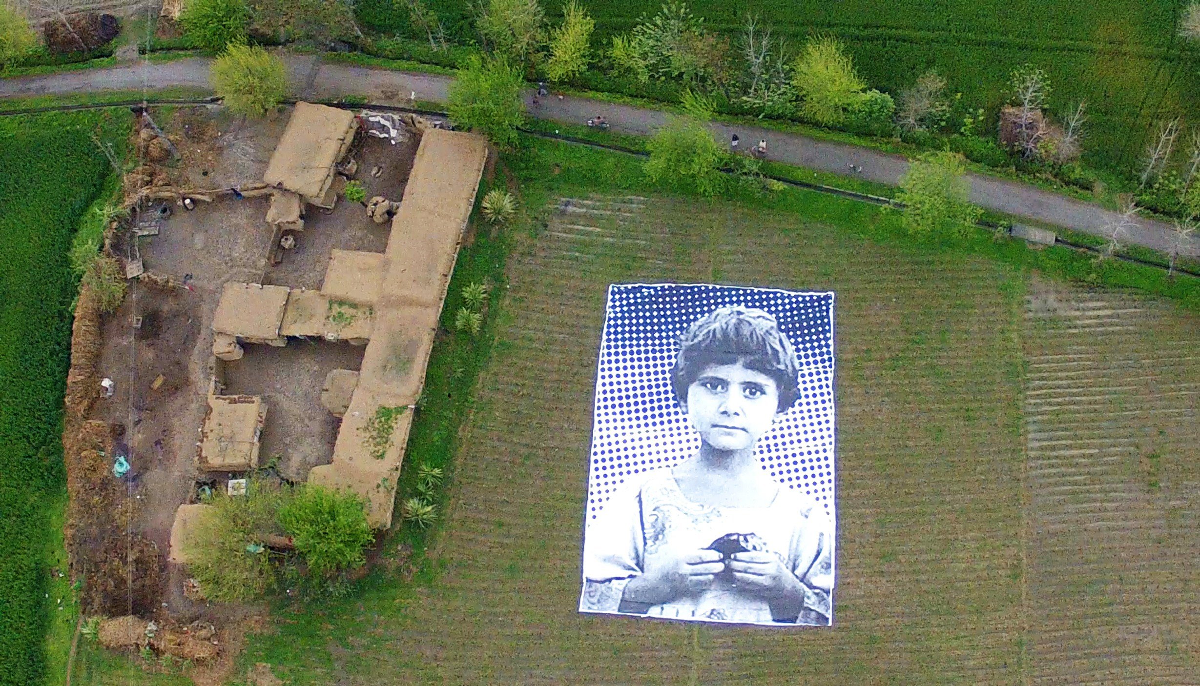 In this undated handout photograph, a poster bearing the image of a Pakistani girl whose parents, lawyers say, were killed in a drone strike, lies in a field at an undisclosed location in the northwestern Khyber-Pakhtunkhwa province.
