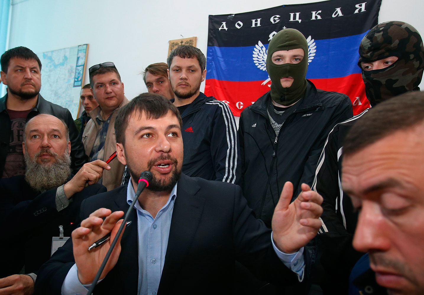Denis Pushilin, foreground center,  spokesman of the self-appointed Donetsk People’s Republic, speaks to reporters inside the regional administration building seized earlier in Donetsk, Ukraine, April 18, 2014. 