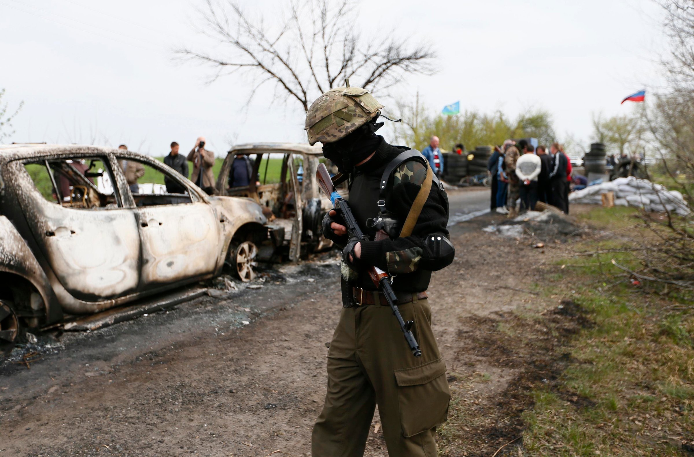 A Pro-Russian militant walks near a checkpoint that was the scene of a gunfight overnight near the city of Slaviansk, April 20, 2014.