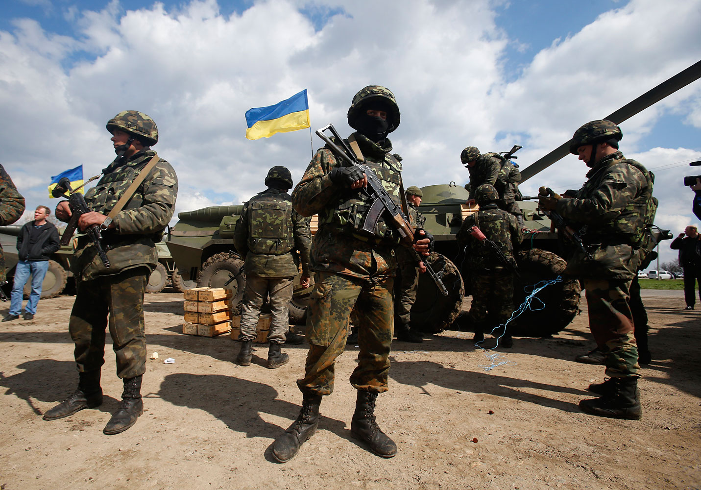 Ukrainian army troops receive ammunition, with a Ukrainian flag in the back, in a field on the outskirts of Izyum, Eastern Ukraine, April 15, 2014.