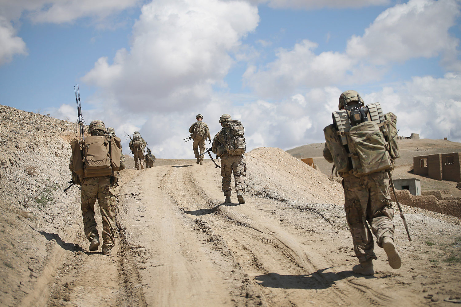 Soldiers with the U.S. Army's 2nd Battalion 87th Infantry Regiment, 3rd Brigade Combat Team, 10th Mountain Division patrol on the edge of a village outside of Forward Operating Base Shank on March 29, 2014 near Pul-e Alam, Afghanistan.