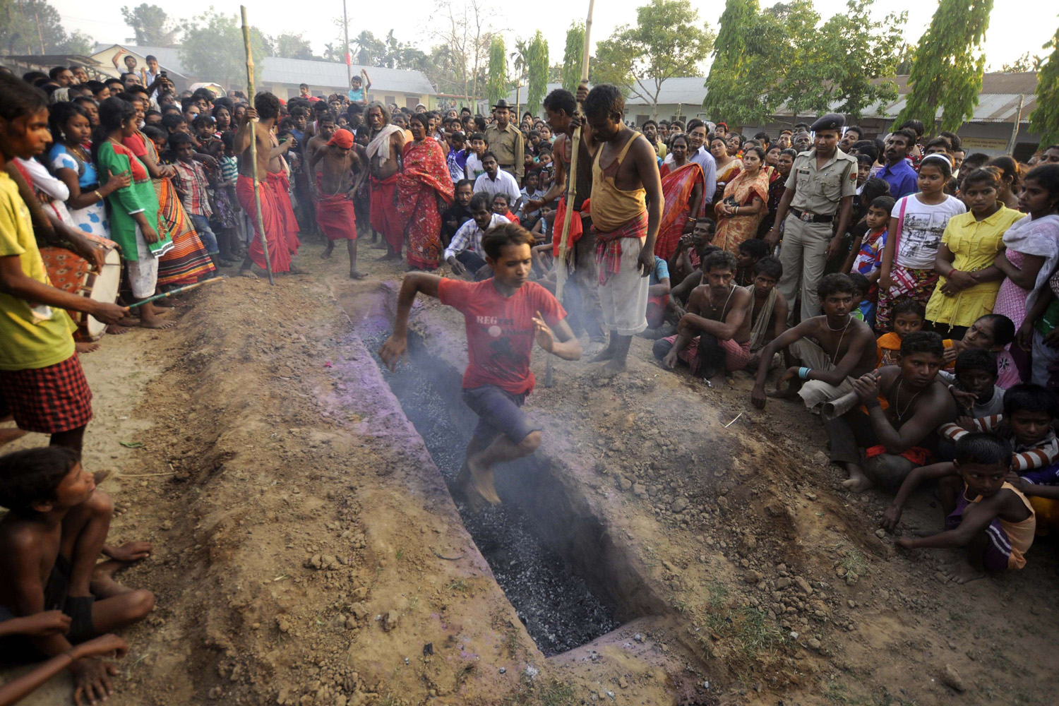 A Hindu devotee runs over smouldering charcoal during the ritual of Shiva Gajan at Pratapgarh village in Agartala, the capital of northeastern Indian state of Tripura, on April 14, 2014.