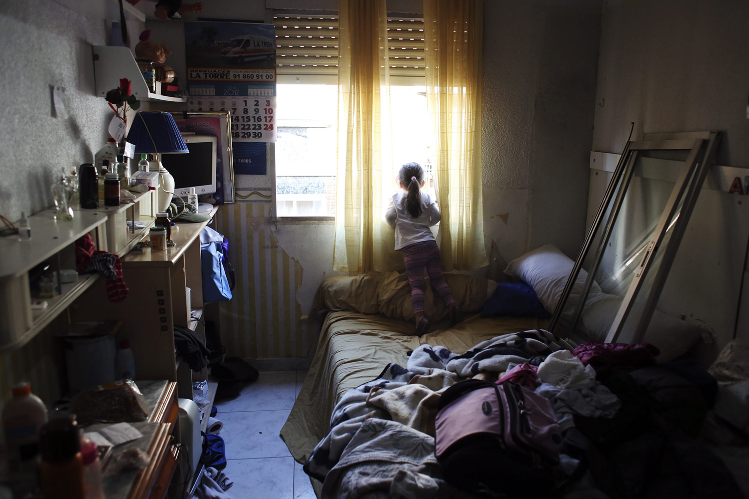 Dayana Chasi Saavedra looks through window after news that their eviction was not going to be carried out, in Madrid