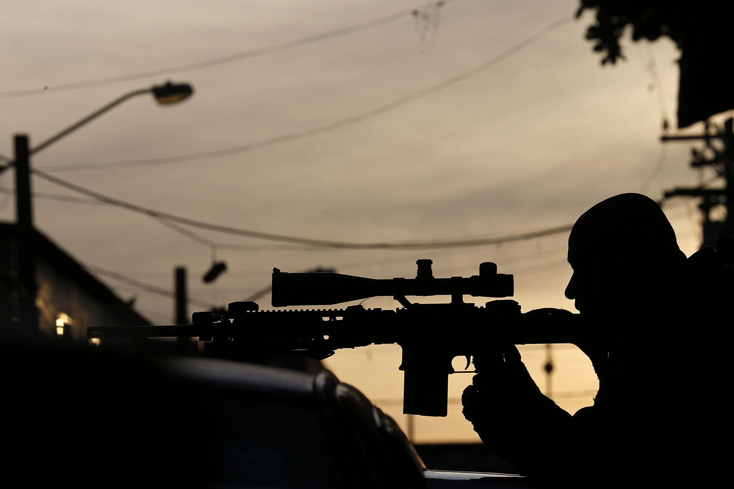 Mar. 30, 2014. A sniper of Special Operations Battalion (BOPE) takes position at the Mare slums complex in Rio de Janeiro.