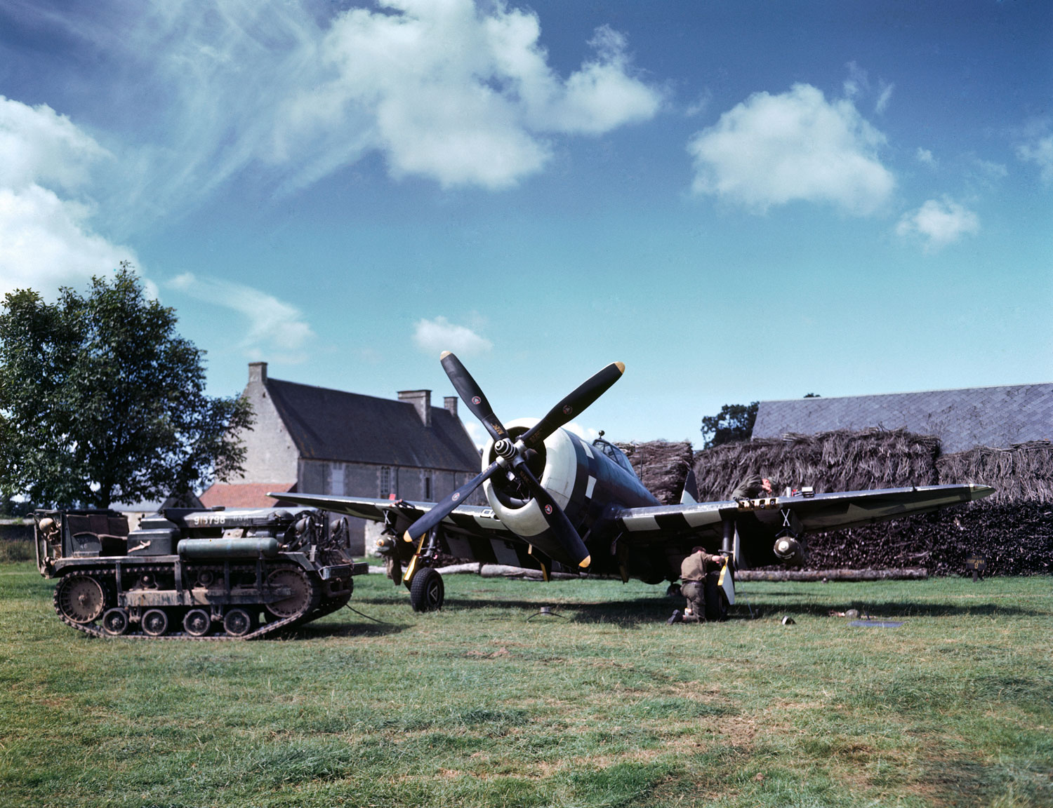 Maintenance work on an American P-47 Thunderbolt in a makeshift airfield in the French countryside, 1944.